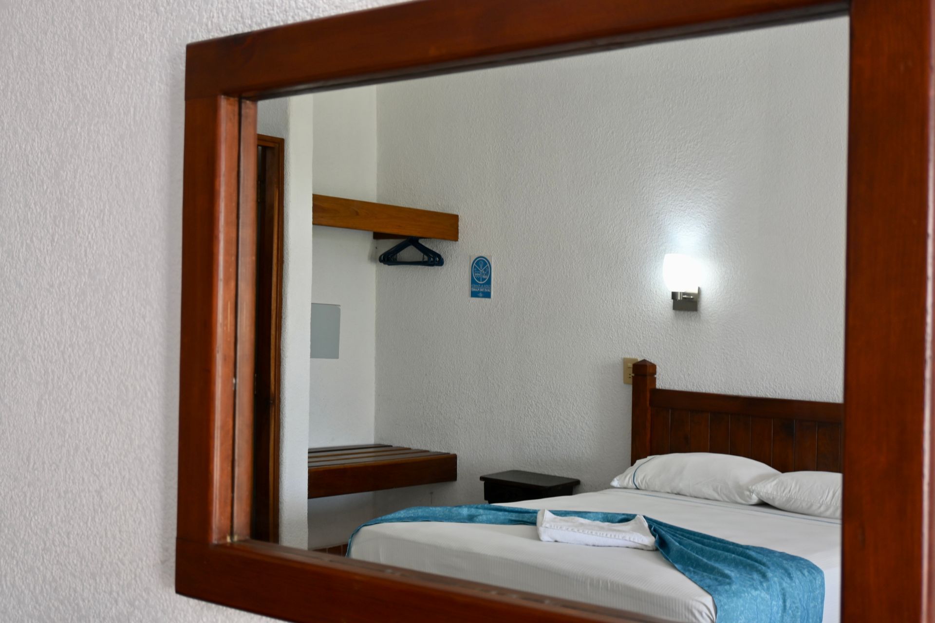 Un dormitorio con una cama y un espejo en la pared.