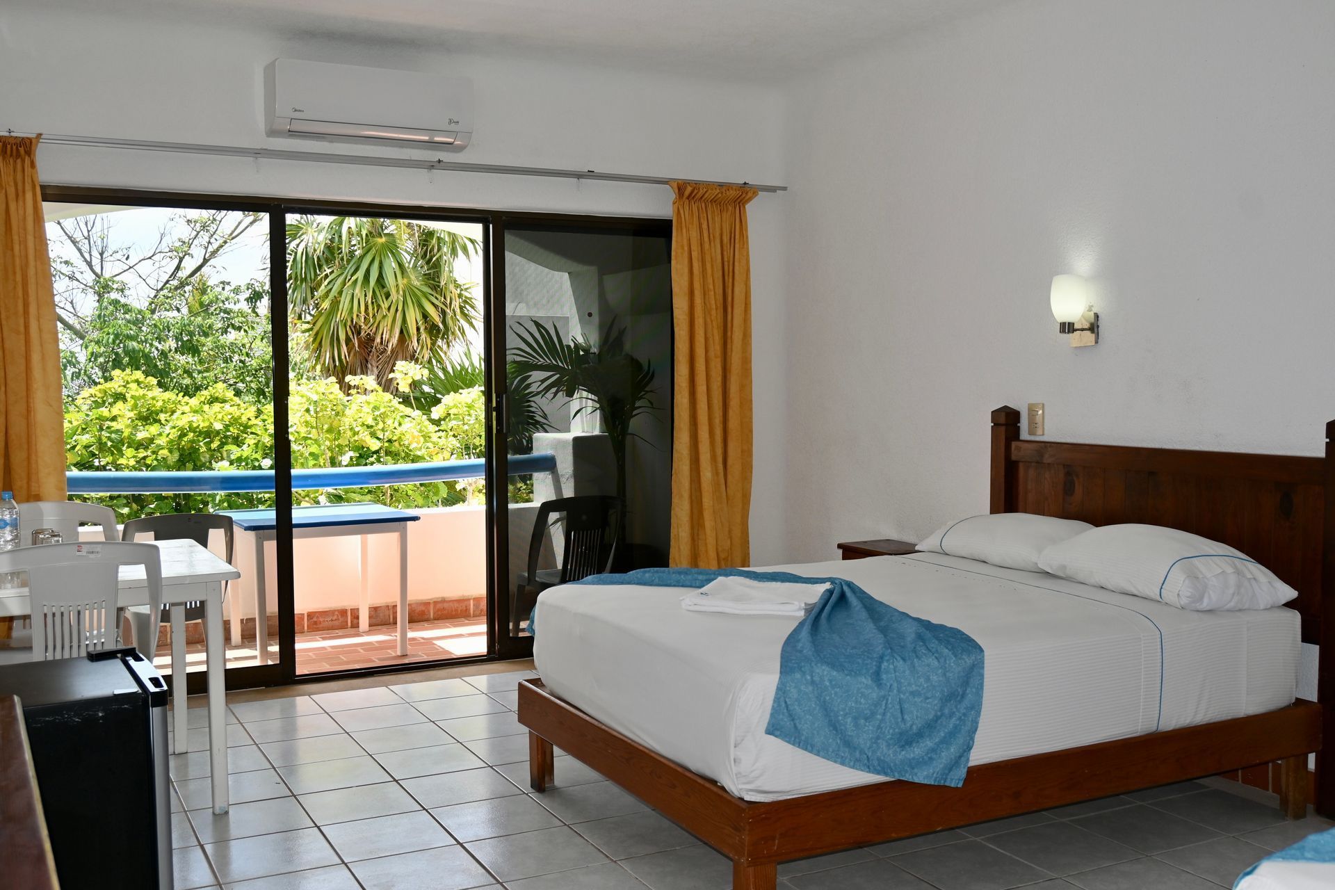 Una habitación de hotel con dos camas y una puerta corrediza de vidrio.