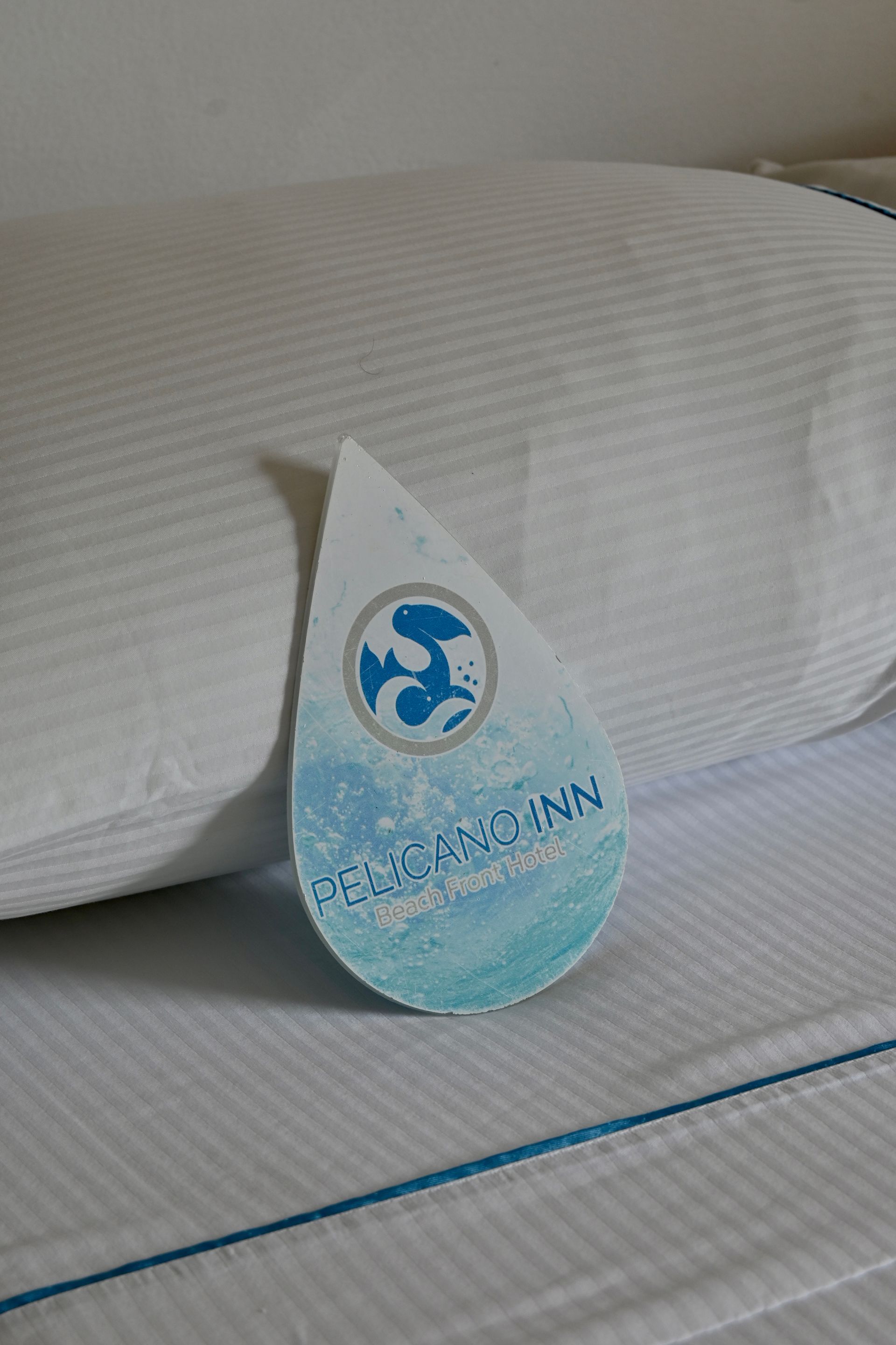 Una almohada con una etiqueta está sobre una cama.