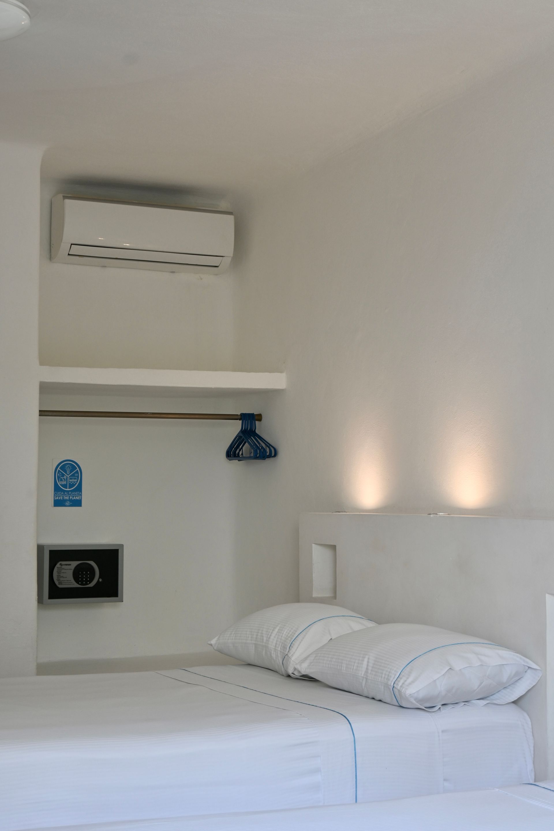 Un dormitorio con dos camas y una caja fuerte en la pared.
