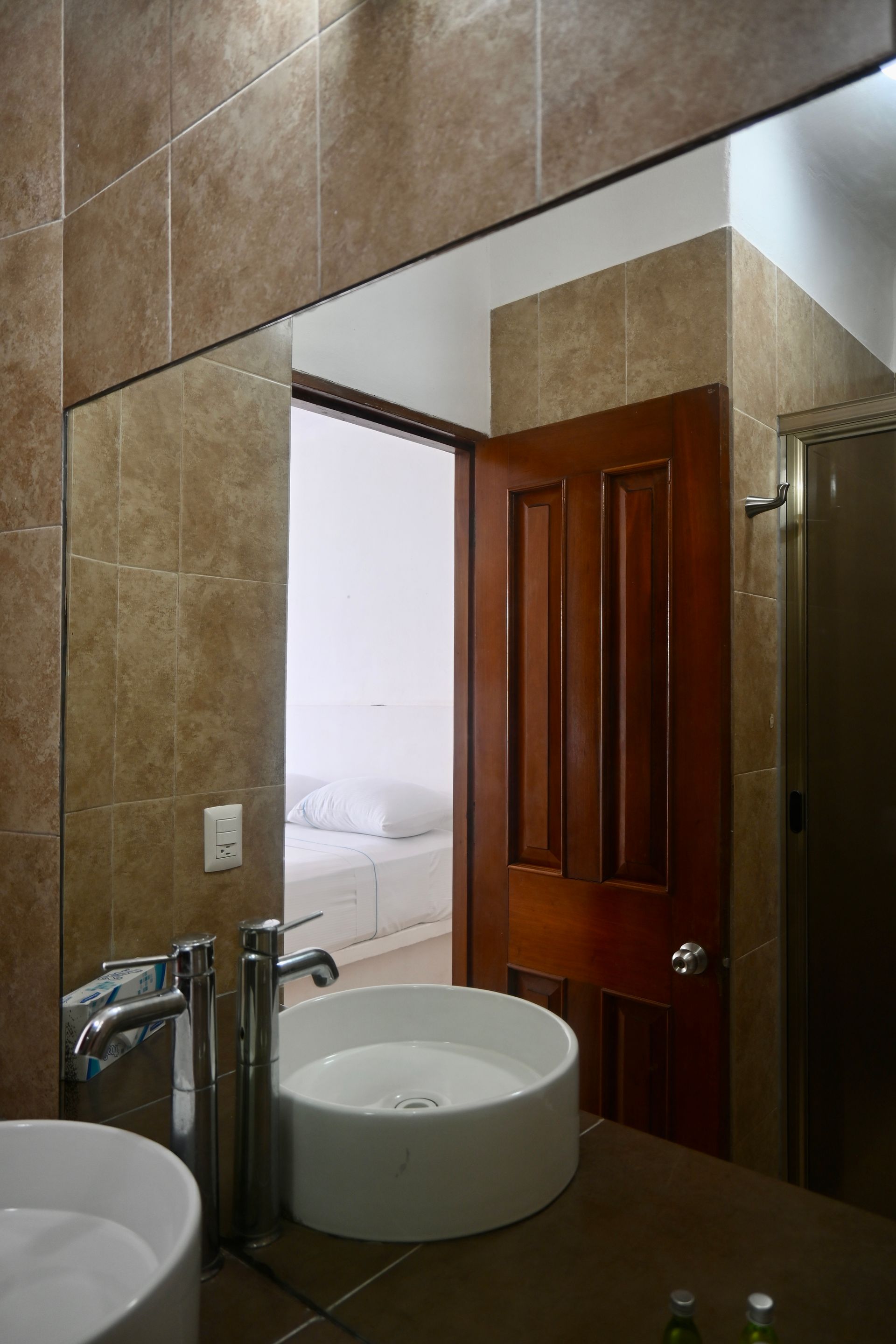 Un baño con dos lavabos y un espejo grande.