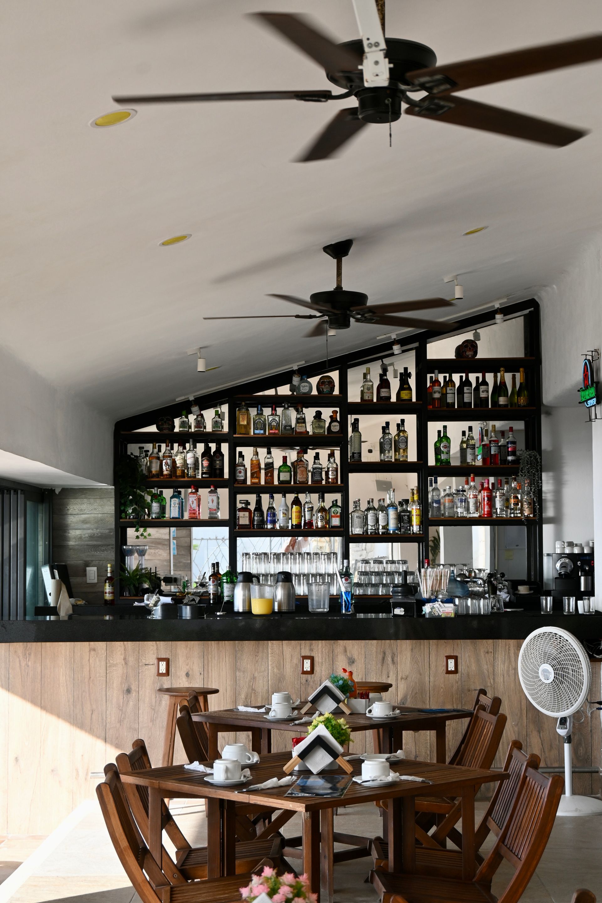 Un restaurante con mesas y sillas y un ventilador de techo.