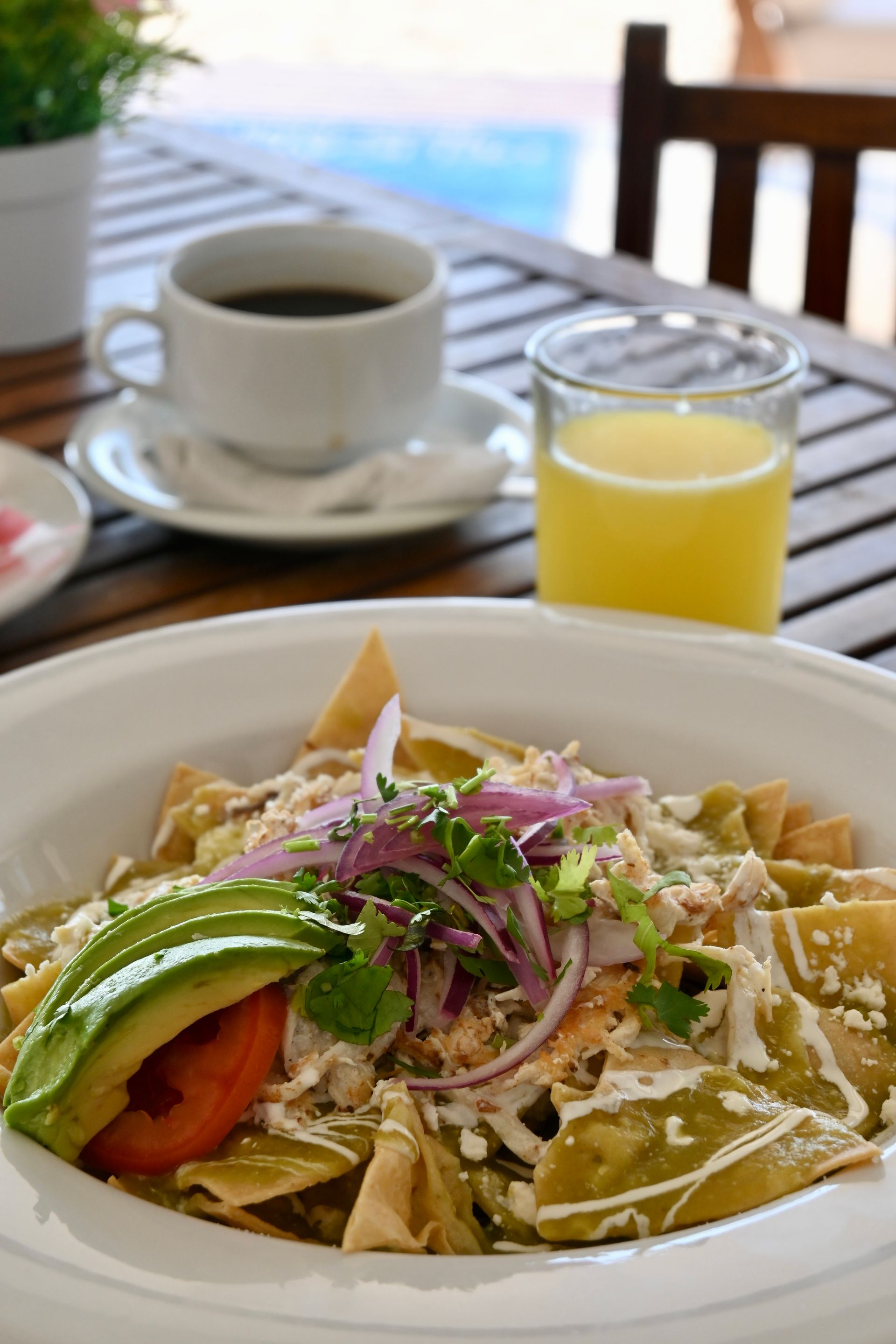 Un primer plano de un plato de comida sobre una mesa con una taza de café y un vaso de jugo de naranja.