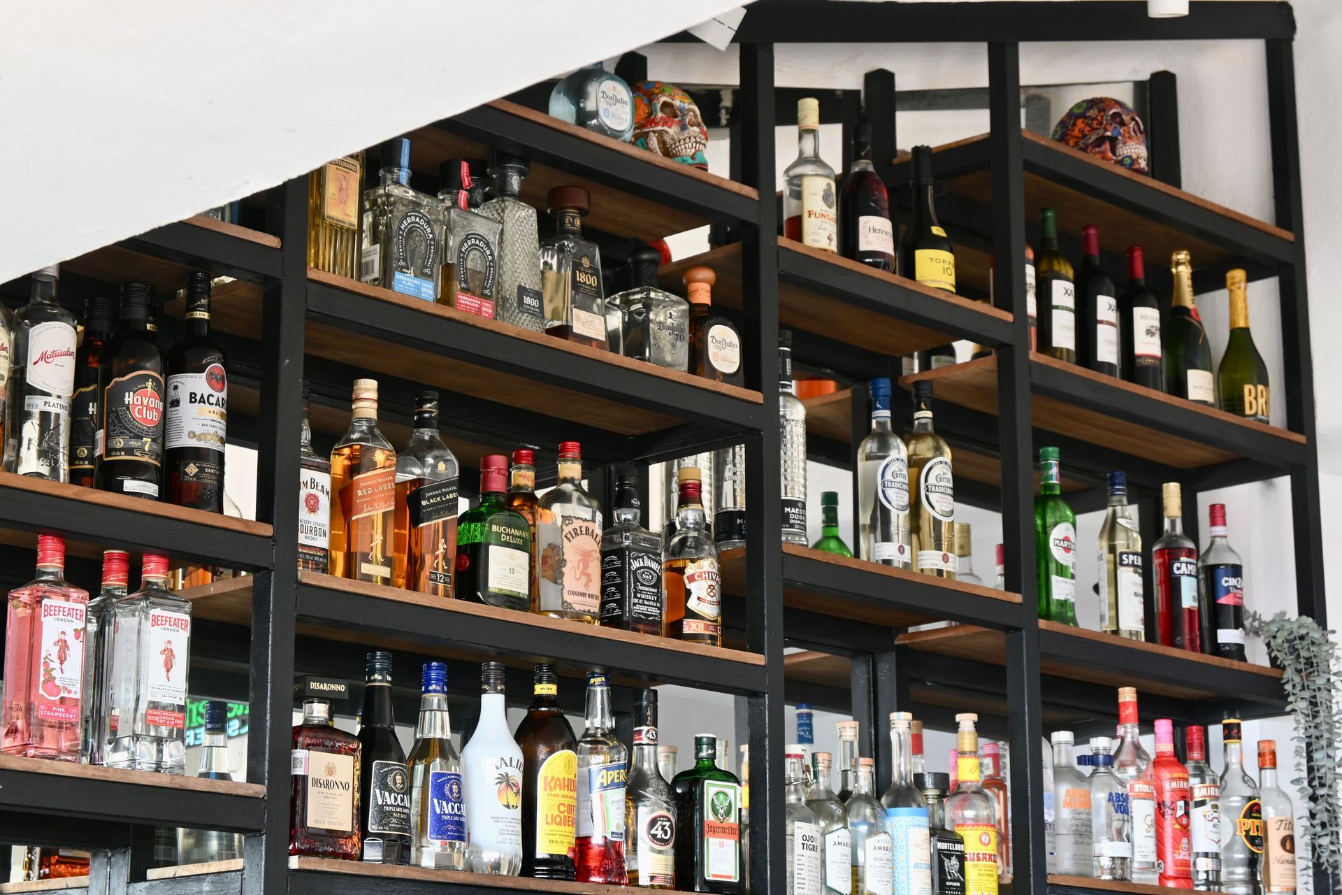 Un estante lleno de muchas botellas de alcohol.