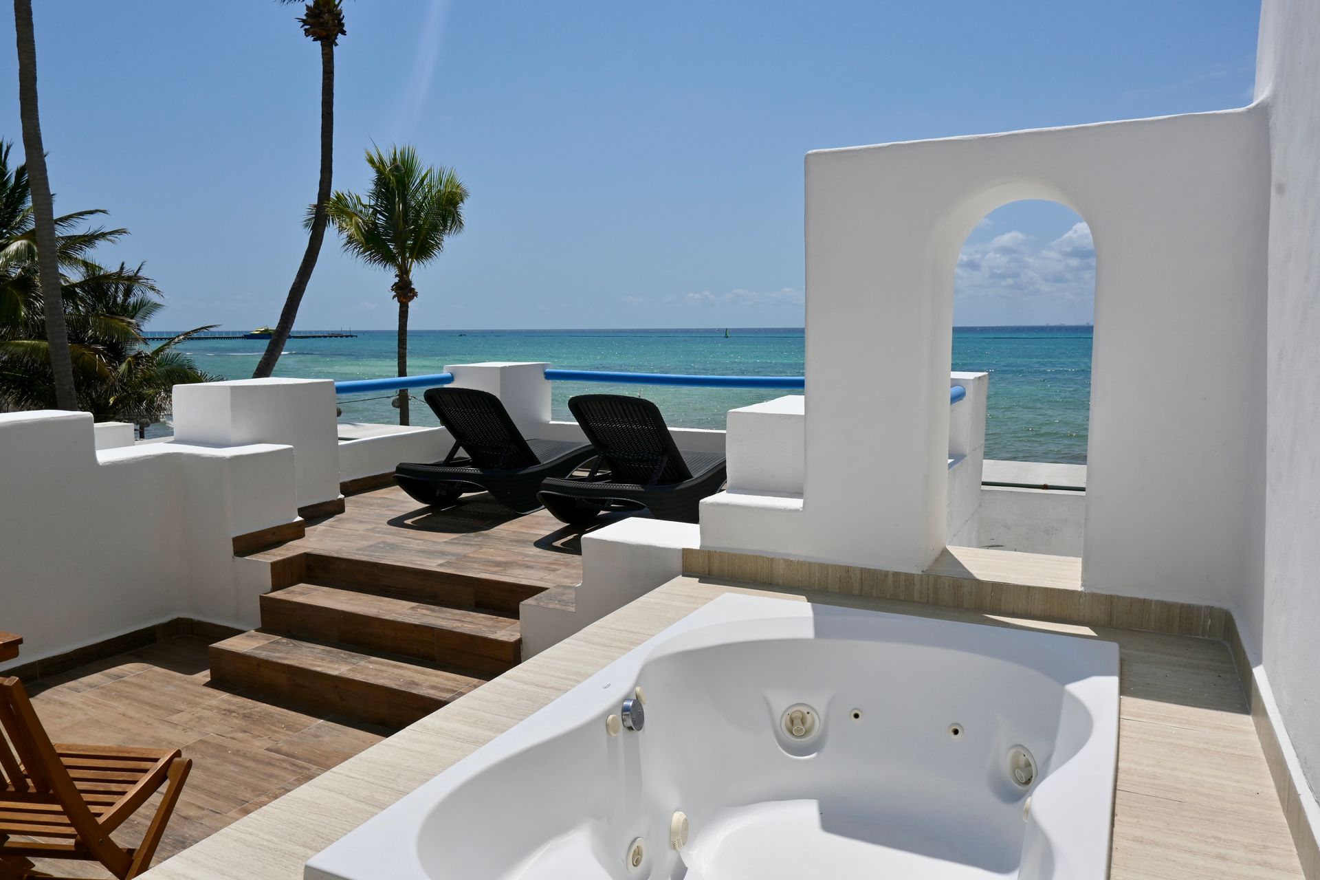Un jacuzzi en un balcón con vista al mar.