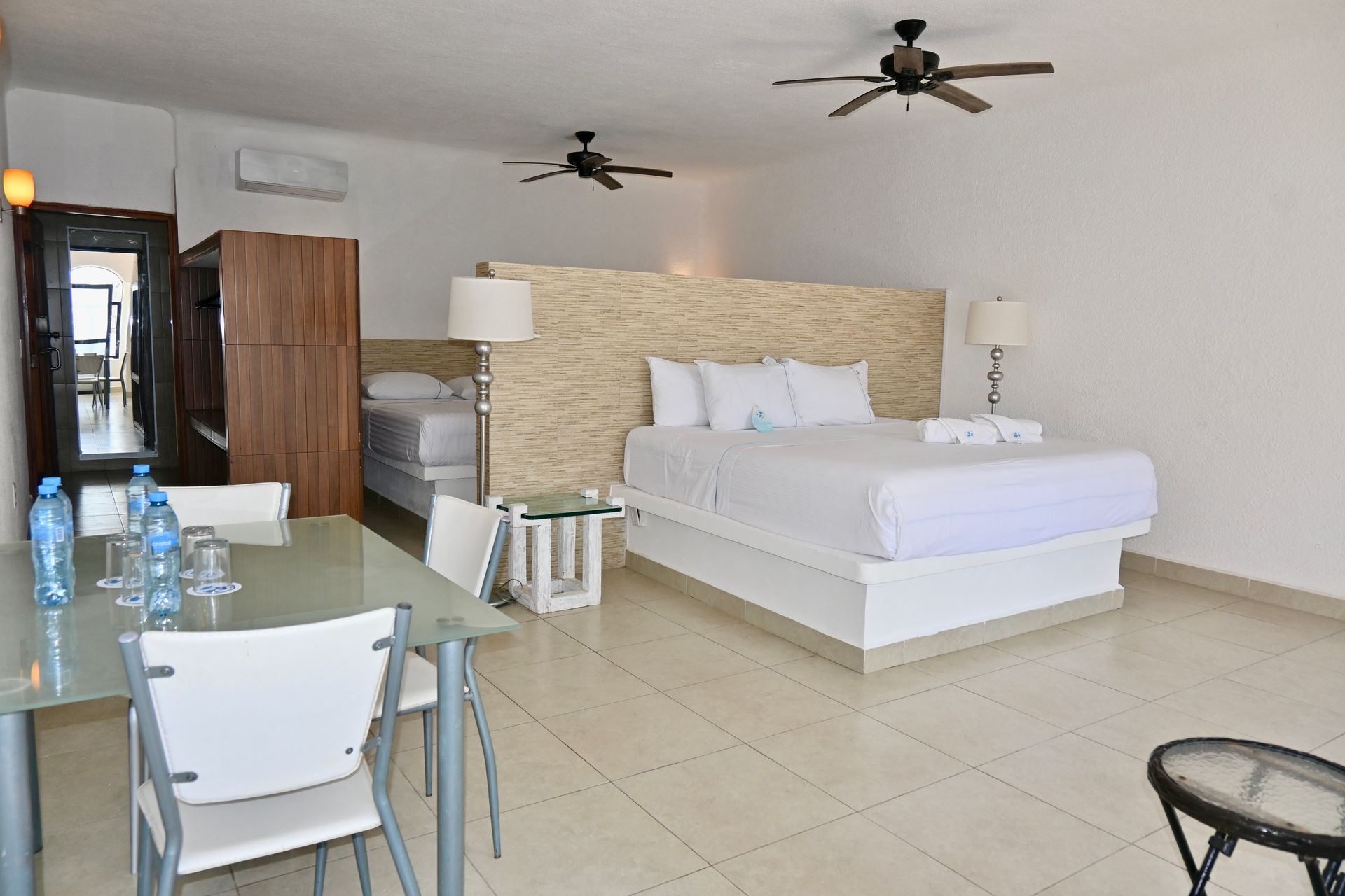 Una habitación de hotel con una cama tamaño king, una mesa y sillas.