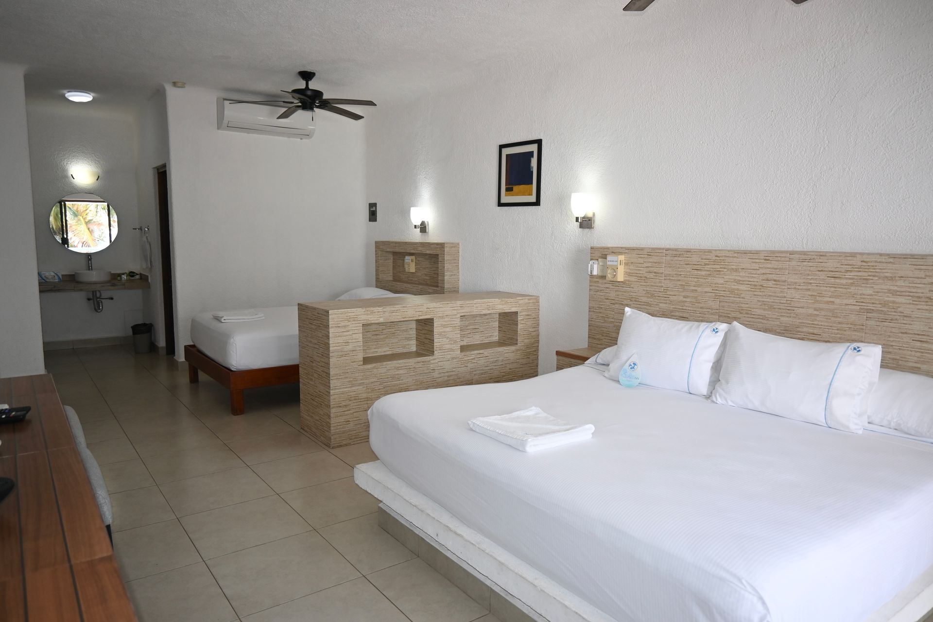 Una habitación de hotel con una cama king size y dos camas individuales.