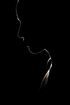 Une silhouette du visage d'une personne dans l'obscurité.