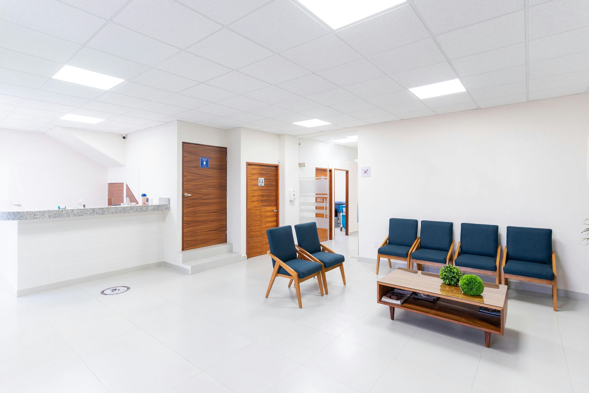Une salle d'attente avec des chaises et une table basse dans un hôpital.