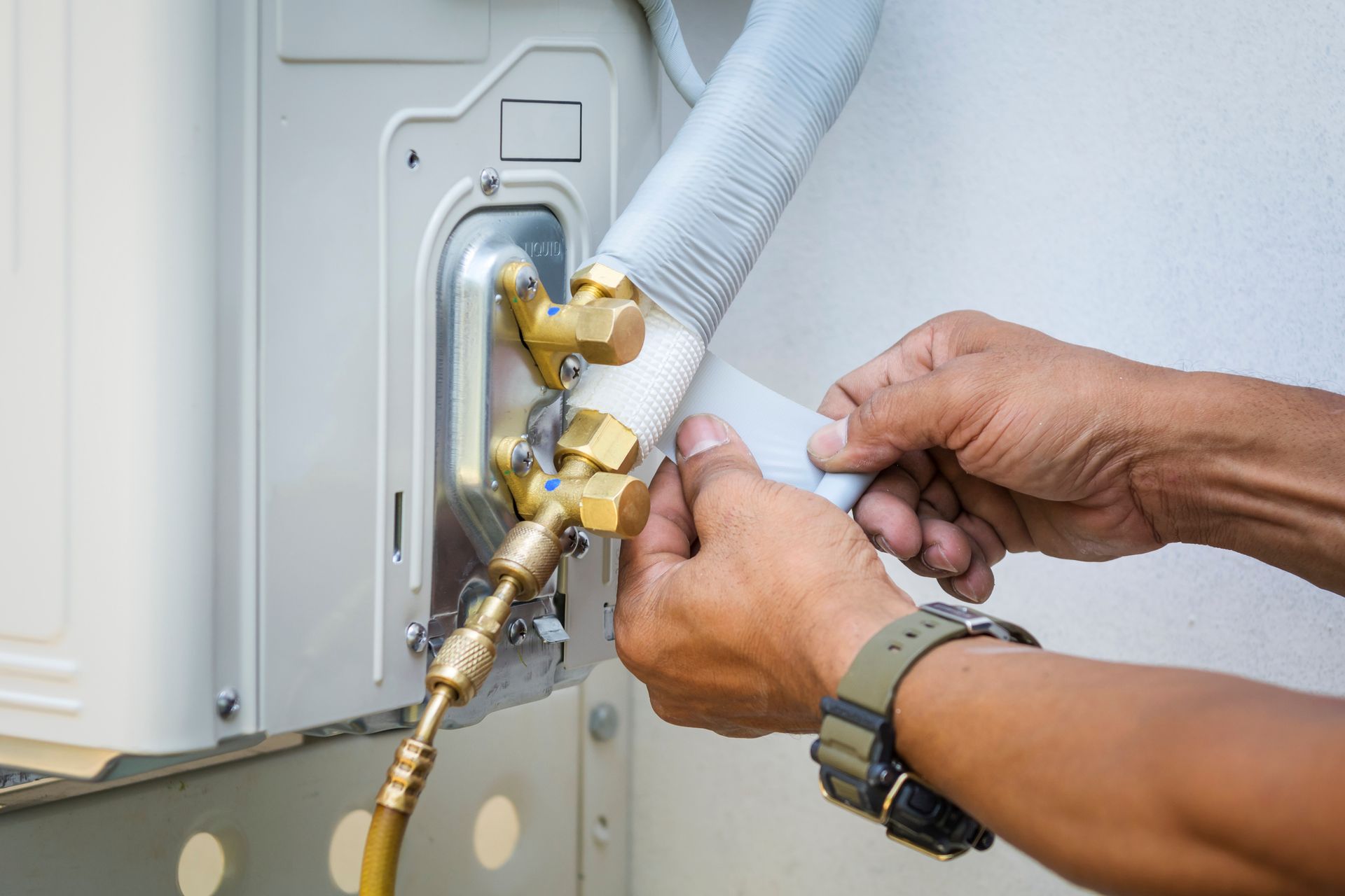 Fixing an Air Conditioner with A Wrench — Cleveland, OH — North East Ohio Heating & Air Conditioning Sales & Service