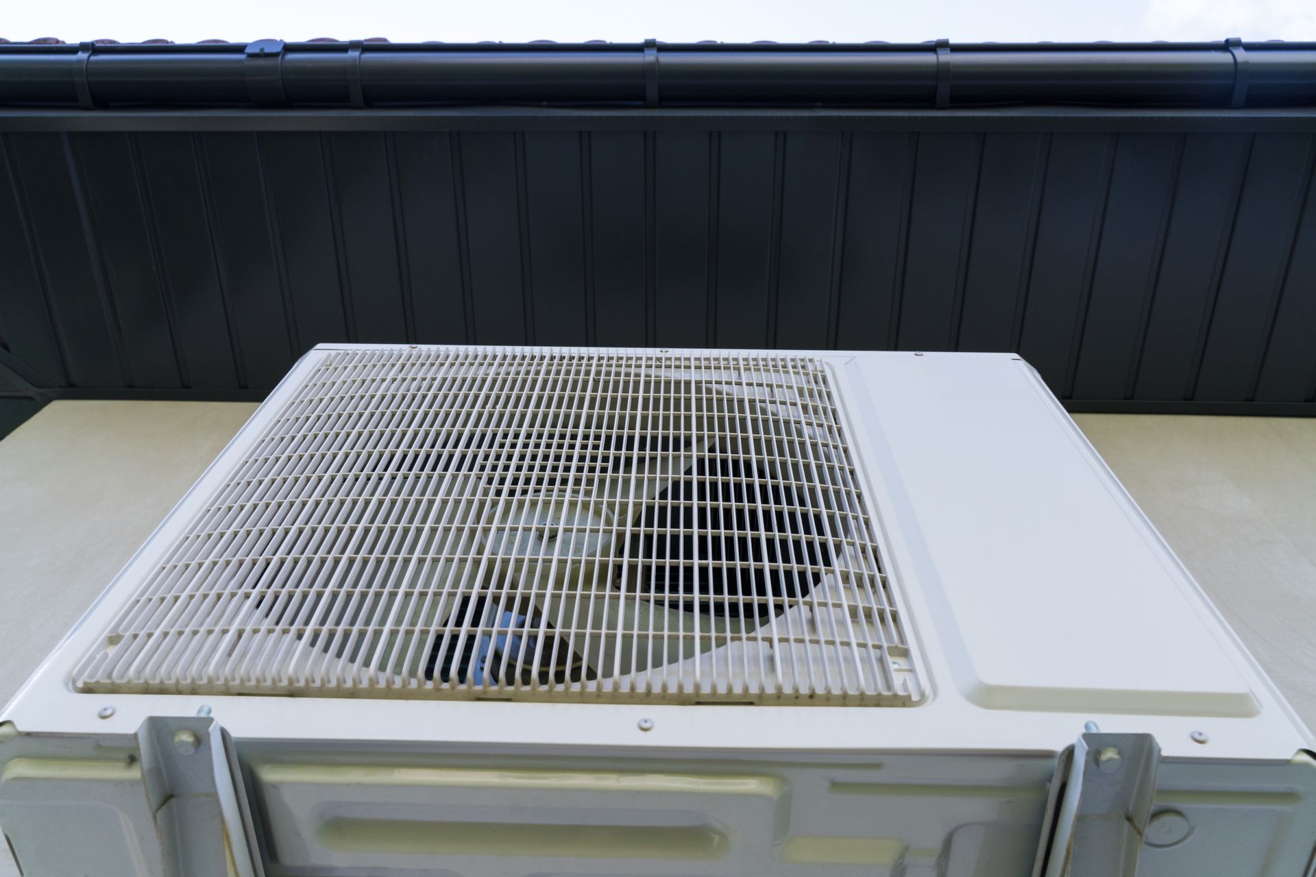 White Air Conditioner on The Side of A Building — Cleveland, OH — North East Ohio Heating & Air Conditioning Sales & Service