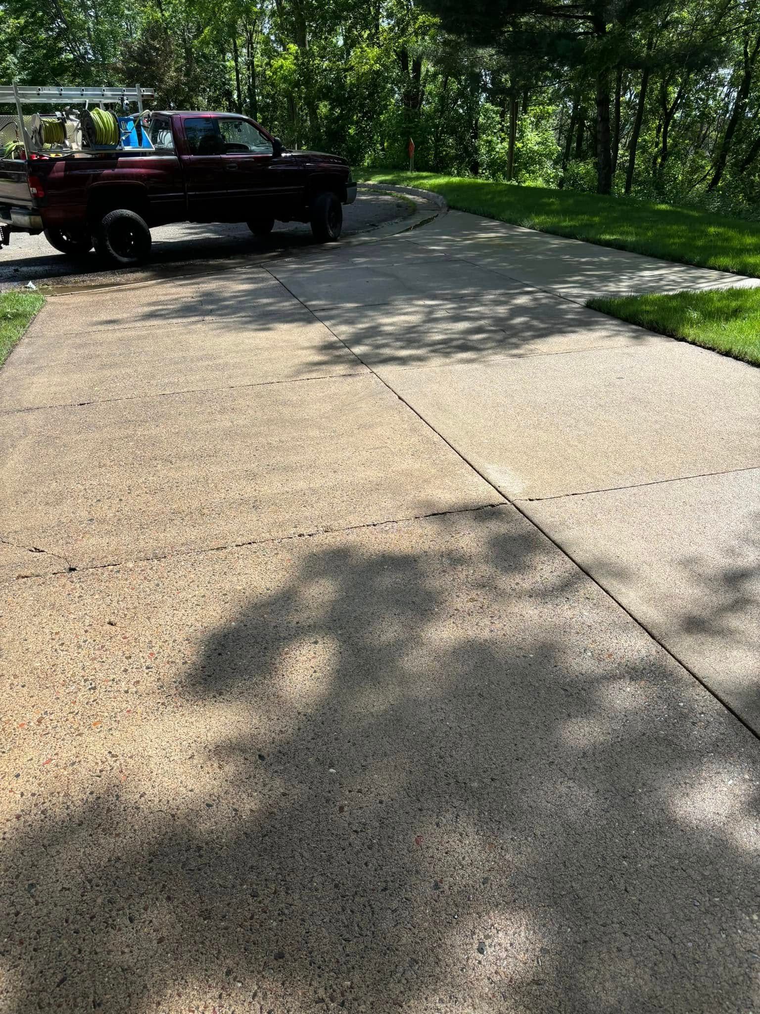 Driveway beside a black pickup truck in a leafy, sunlit residential area