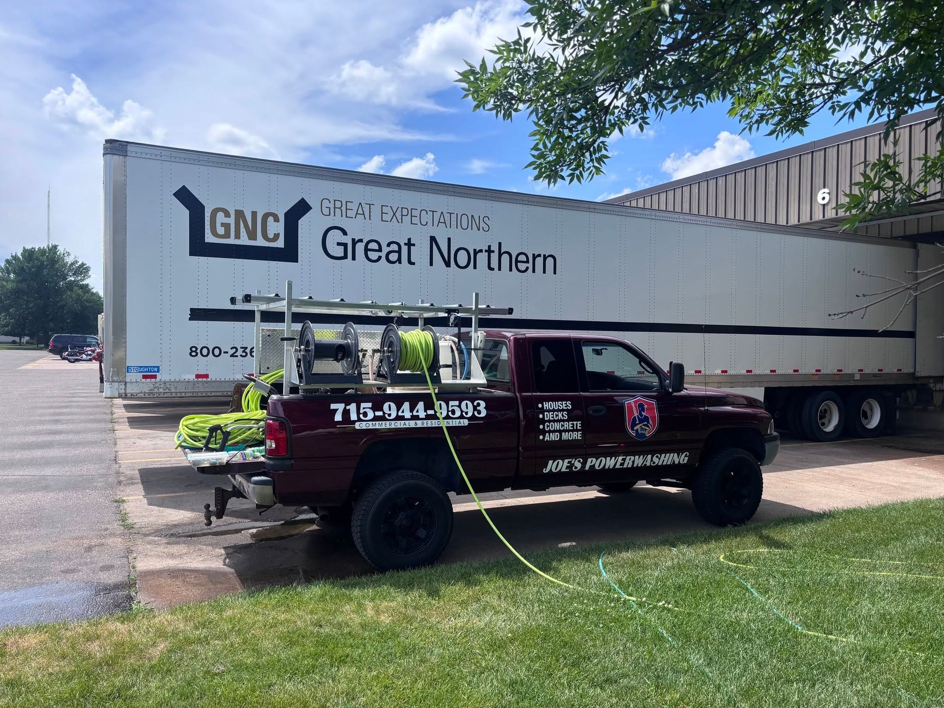 Black pickup truck parked beside a Great Northern trailer in a sunny lot.