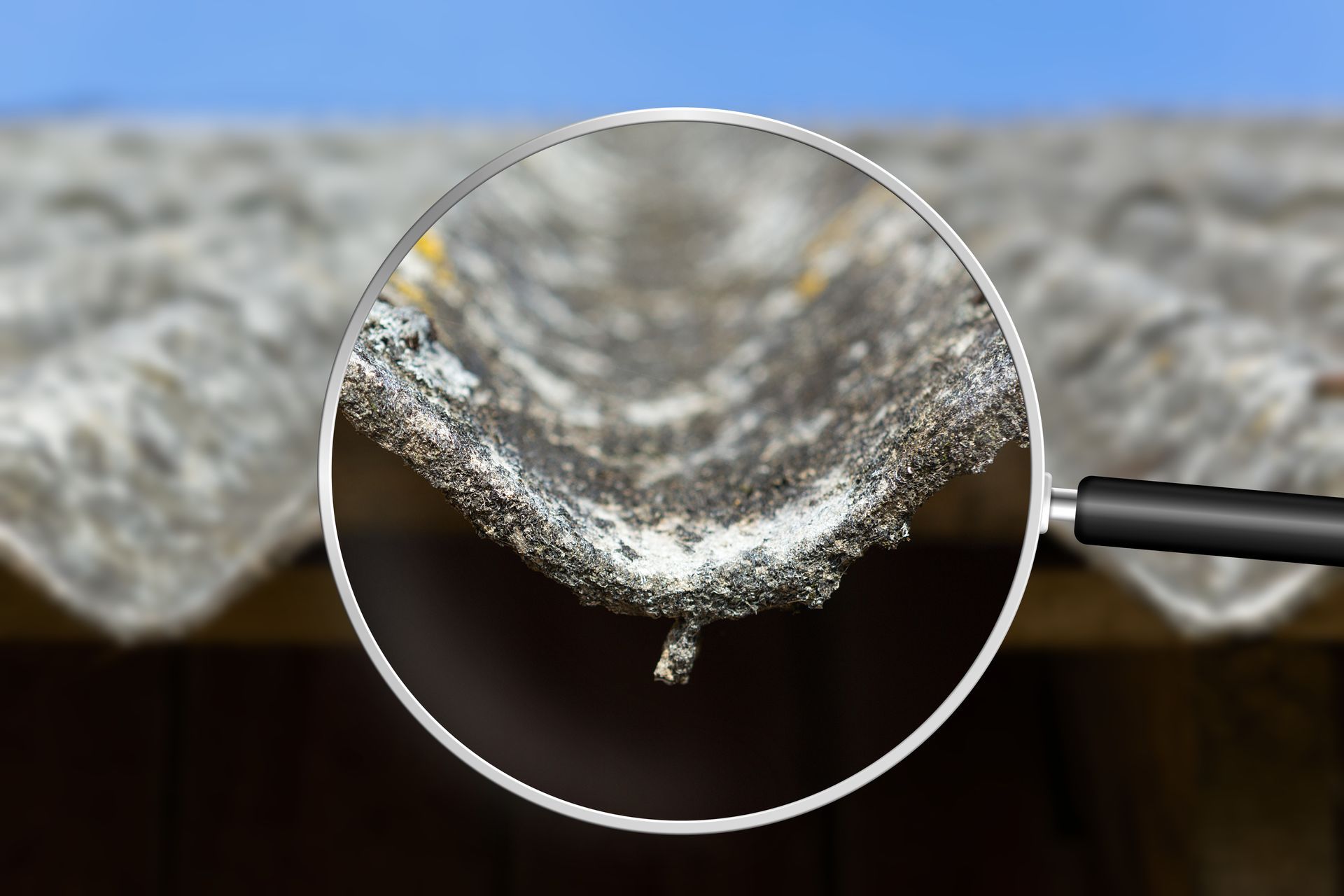 An old and very dangerous asbestos roof viewed through a magnifying glass. An old and very dangerous asbestos roof viewed through a magnifying glass.