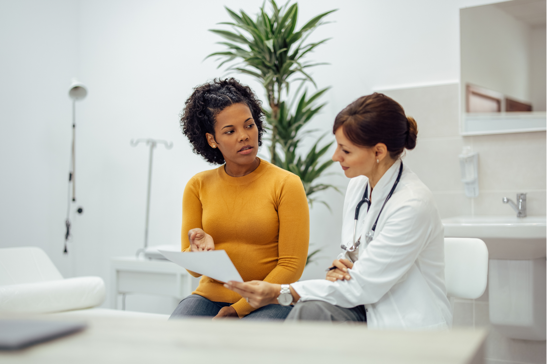 Patient and doctor discussing paperwork in a bright clinic room
