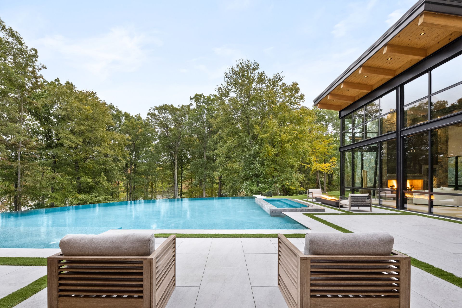 There is a large swimming pool in the backyard of a house.