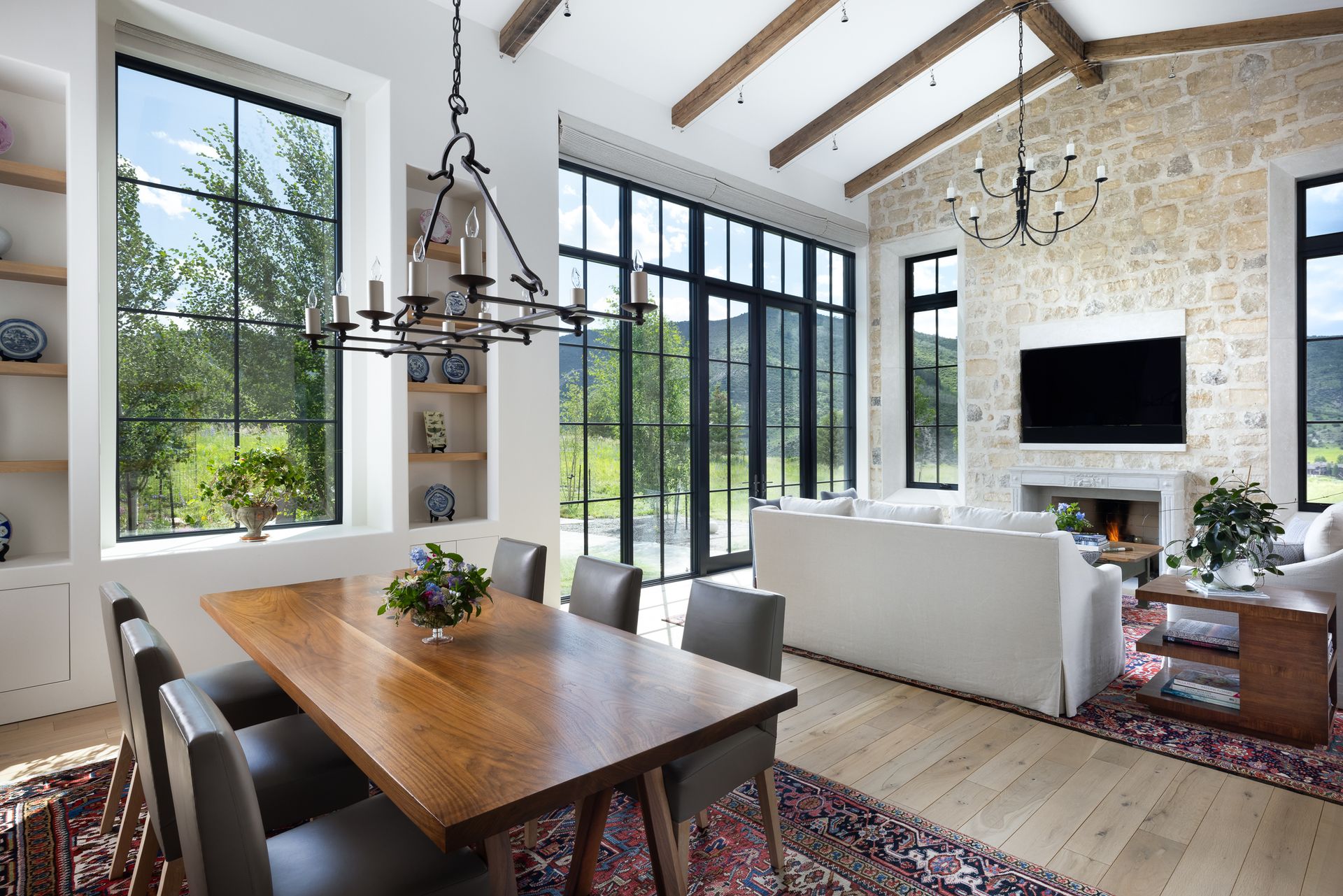 A living room with a wooden table and chairs and a television.