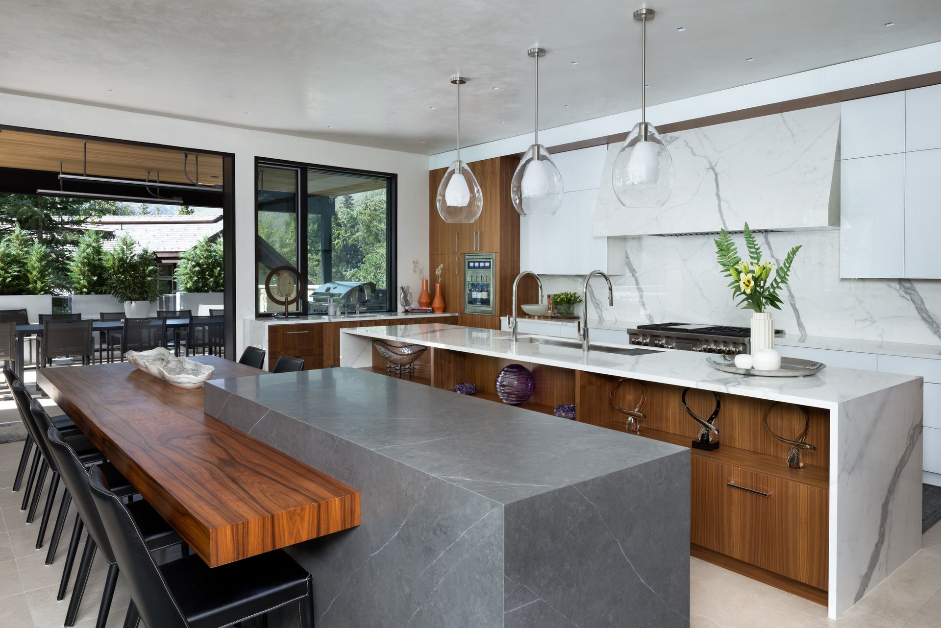 A kitchen with a large island and a long wooden table.