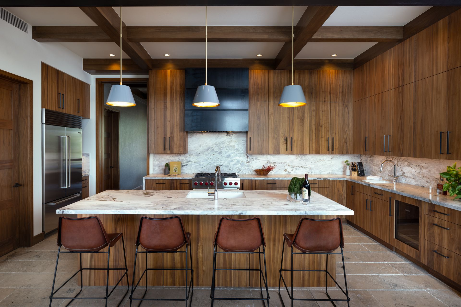 A kitchen with wooden cabinets , marble counter tops , and a large island.