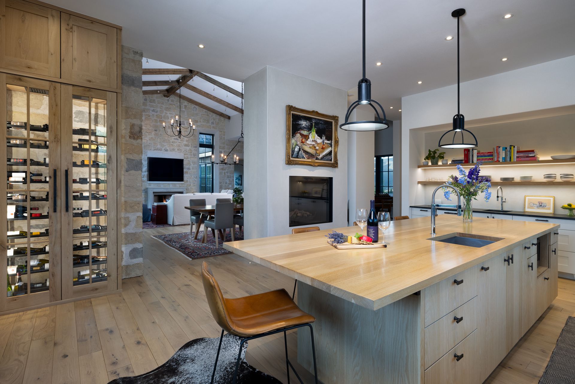 A kitchen with a large island and a wine cellar.