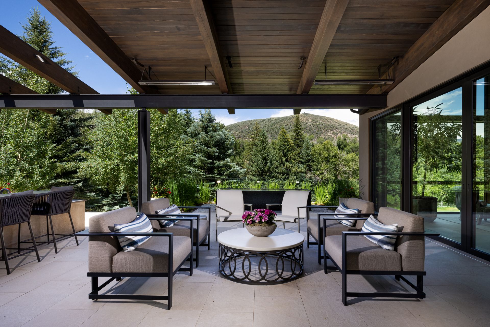 A patio with chairs and a table with a view of the mountains
