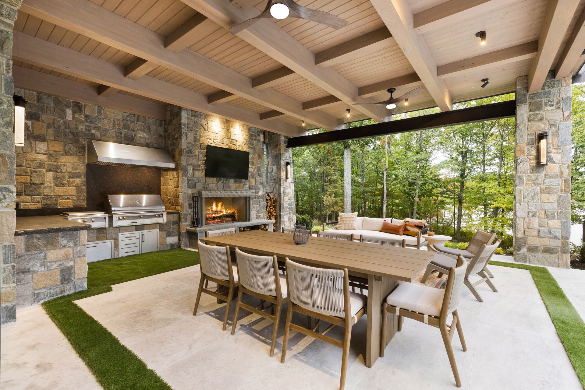 A large patio with a table and chairs and a fireplace.