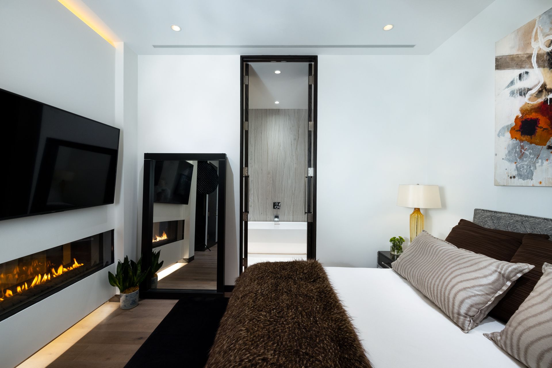 A bedroom with a large bed and a fireplace