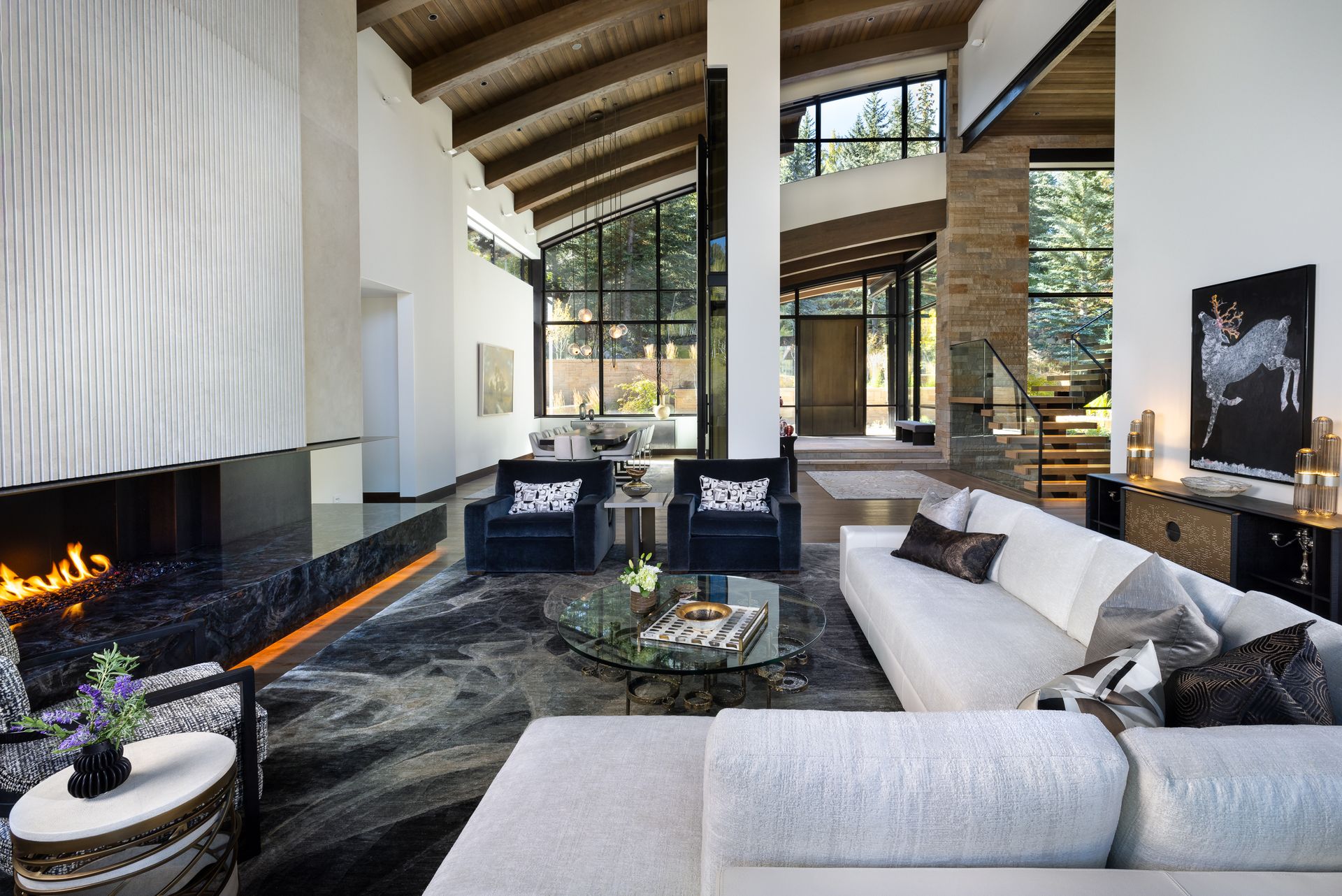 A living room with a couch , chairs and a fireplace.