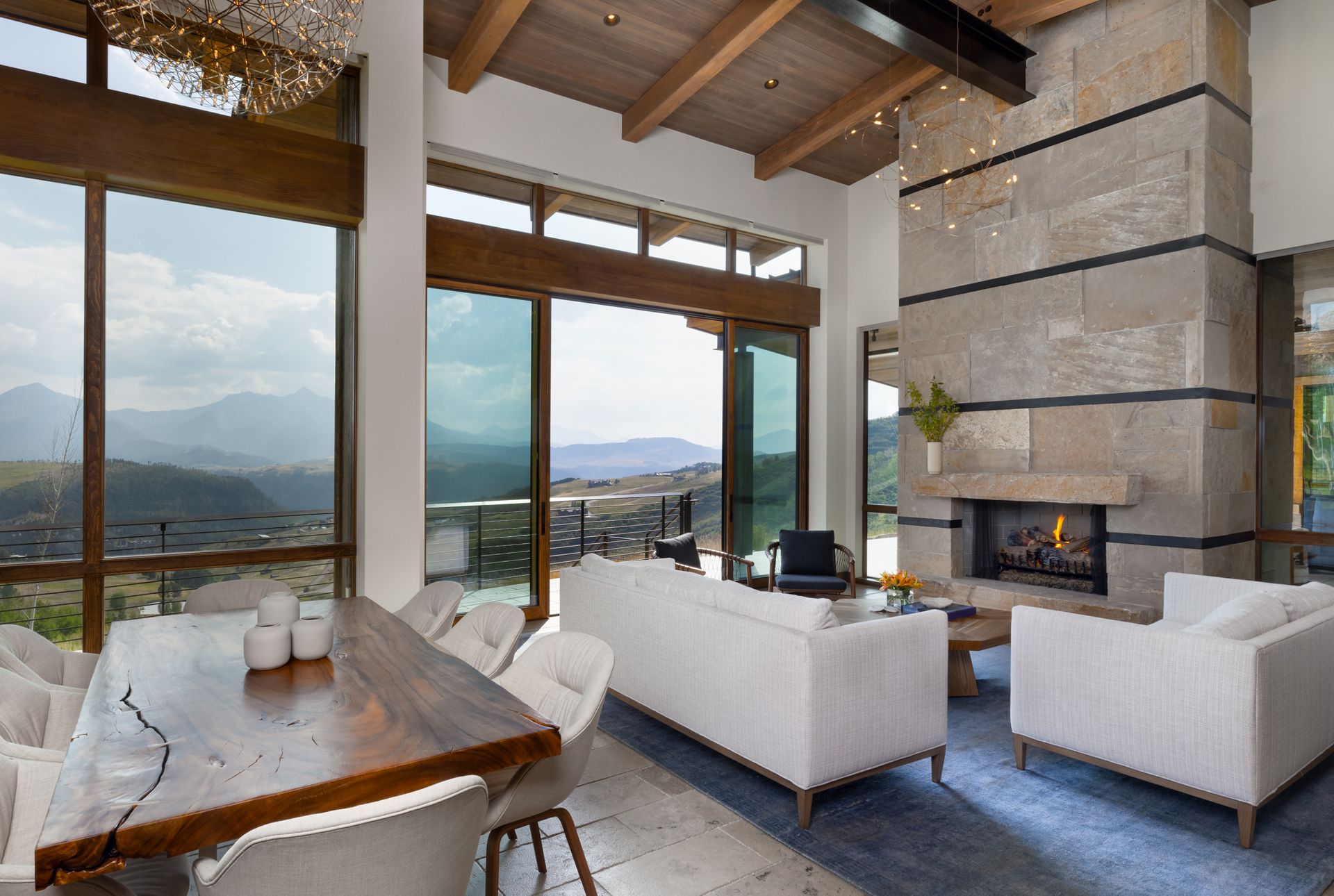 A living room with a fireplace and a view of mountains