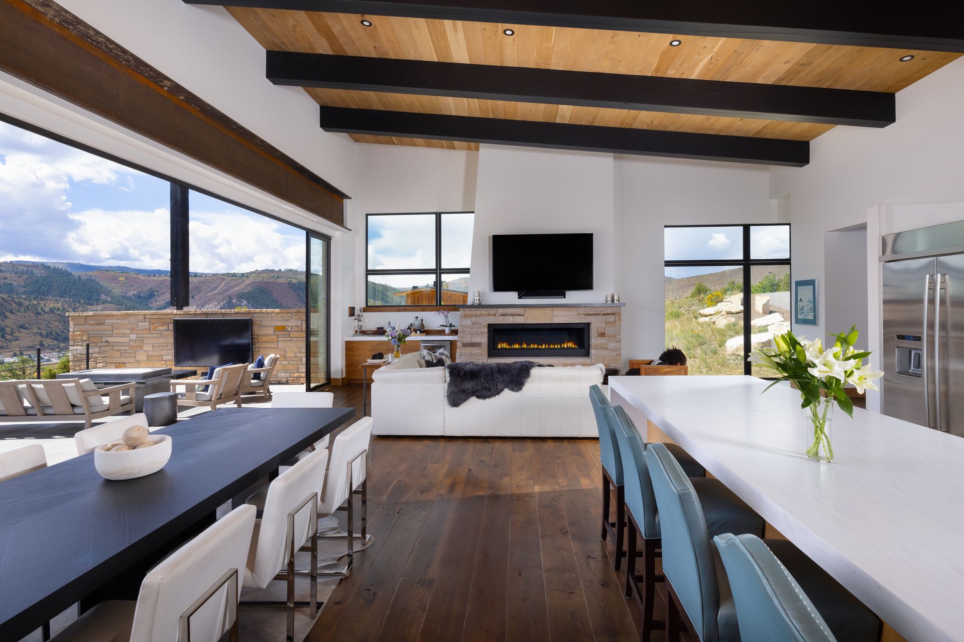 A kitchen with a long table and chairs and a fireplace