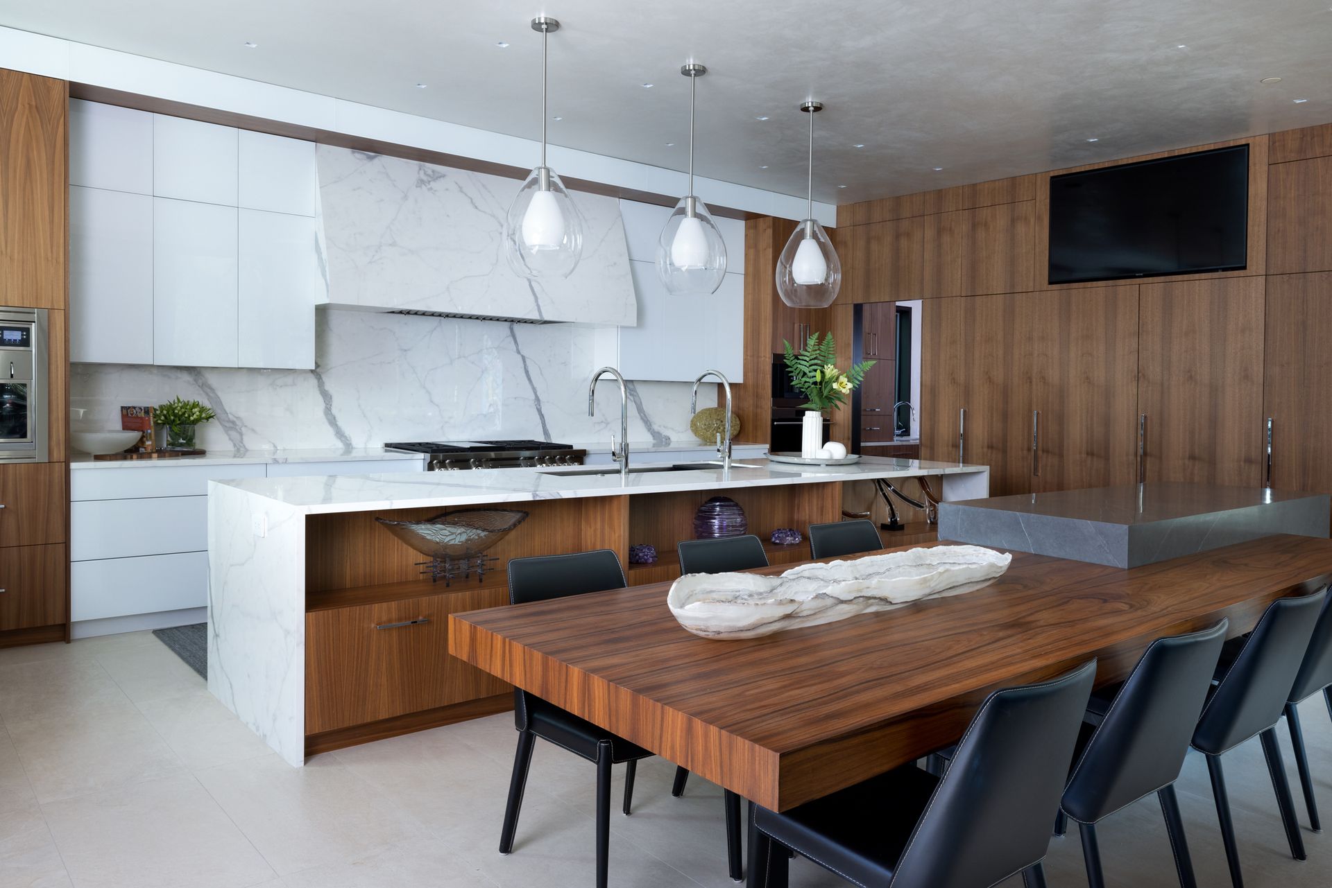 A kitchen and dining room with a large wooden table and chairs.