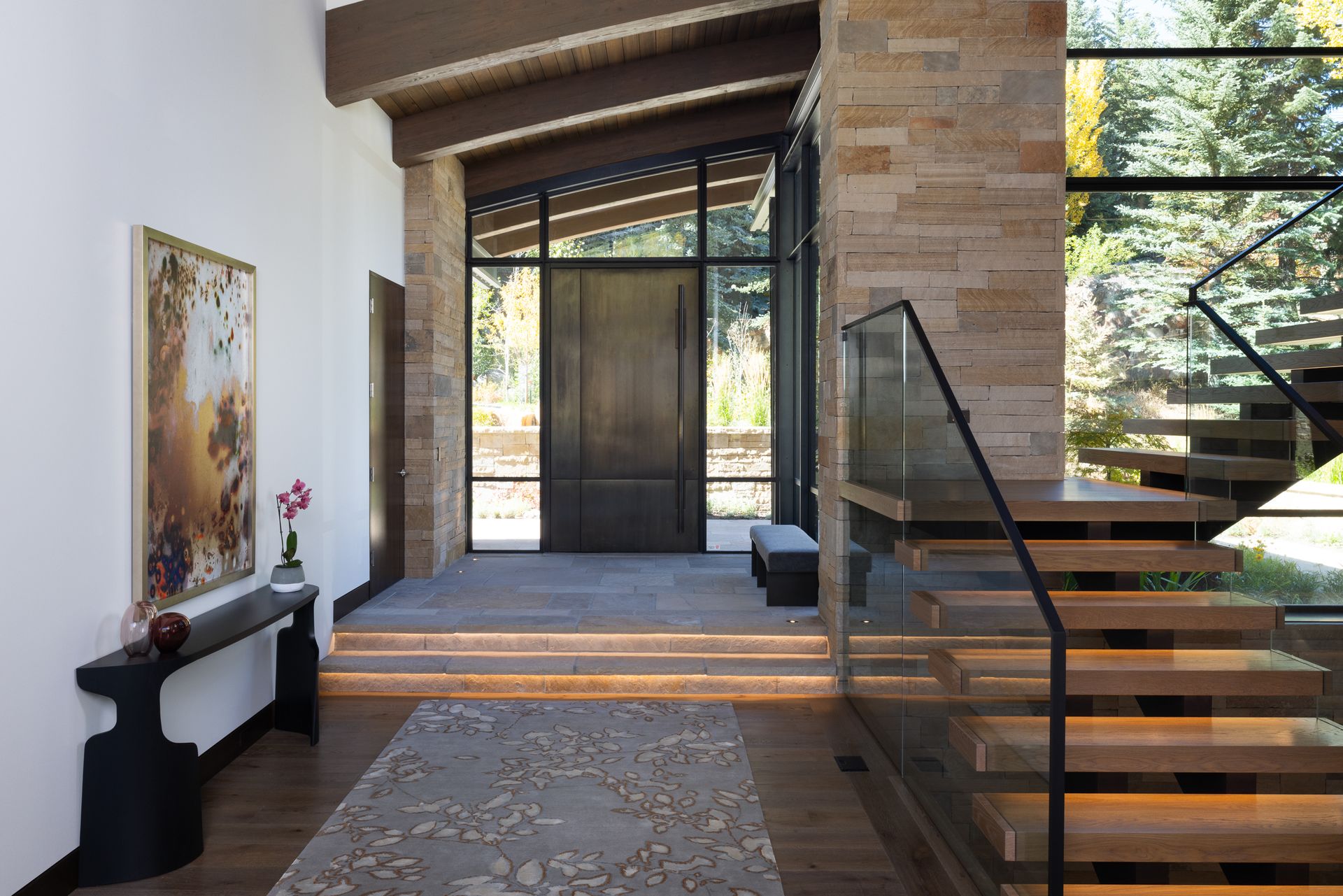 A hallway with a staircase and a large window