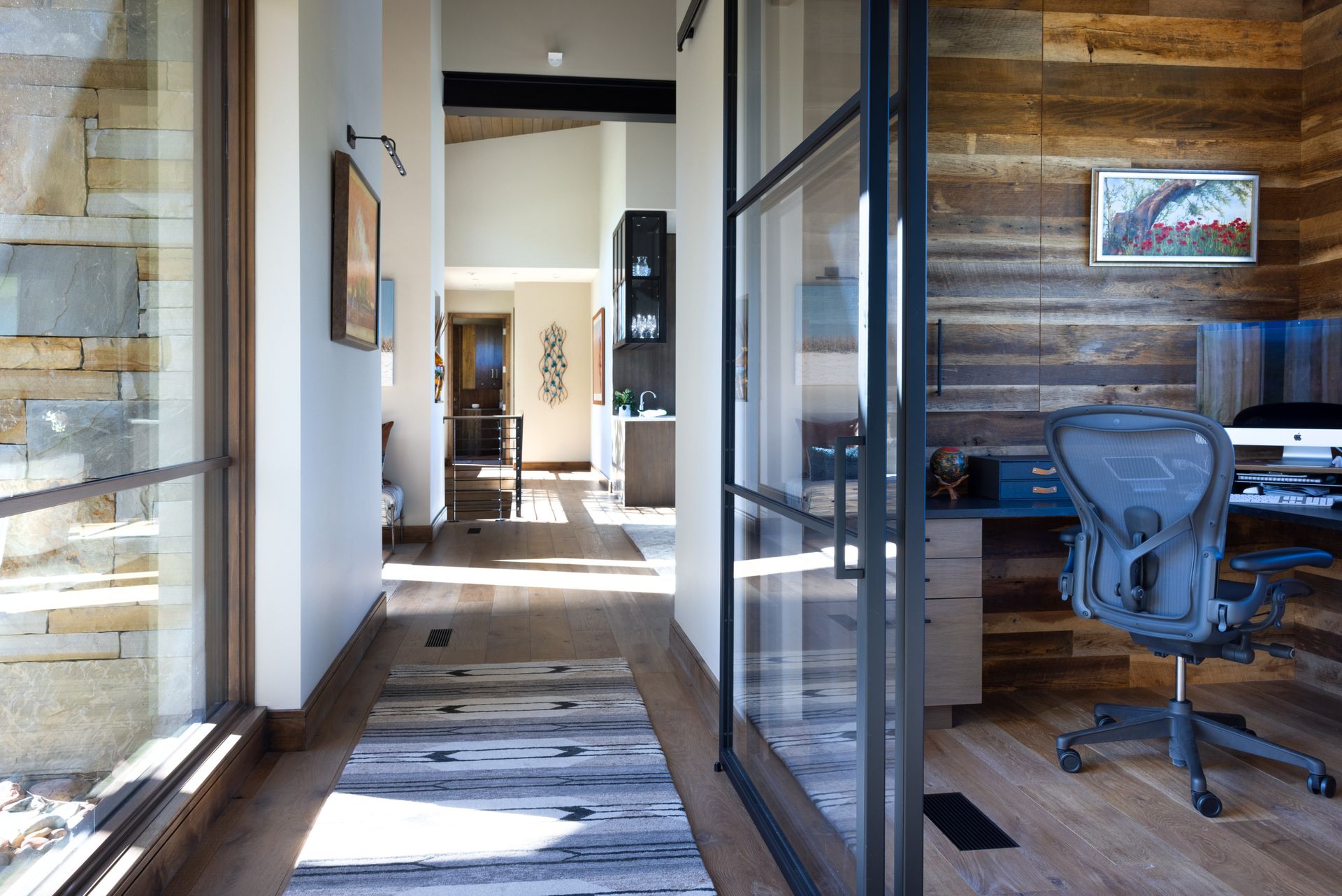 A hallway in a house with a desk and chair