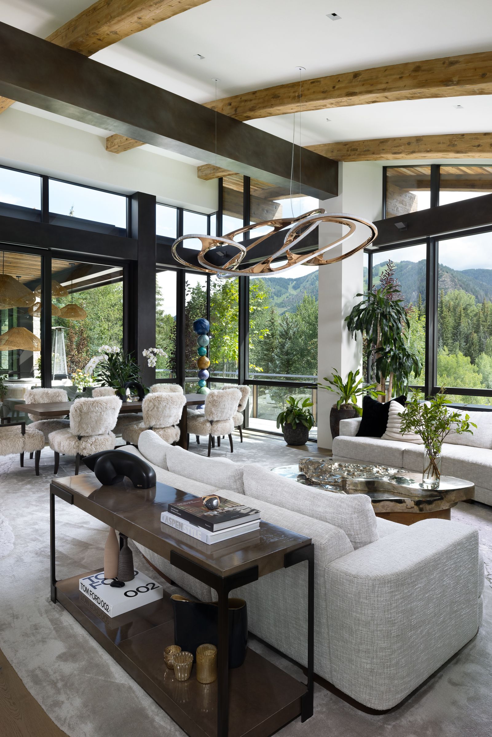 A living room with a couch , table , chairs and lots of windows.