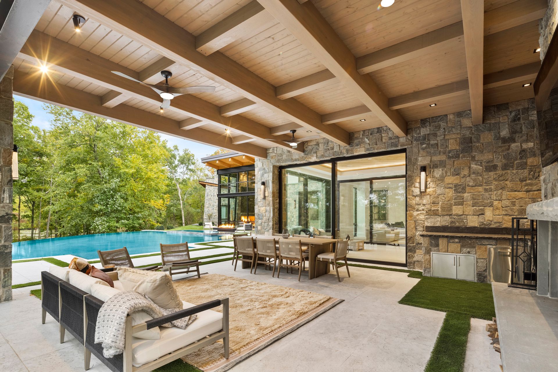 A large patio with a table and chairs and a ceiling fan.