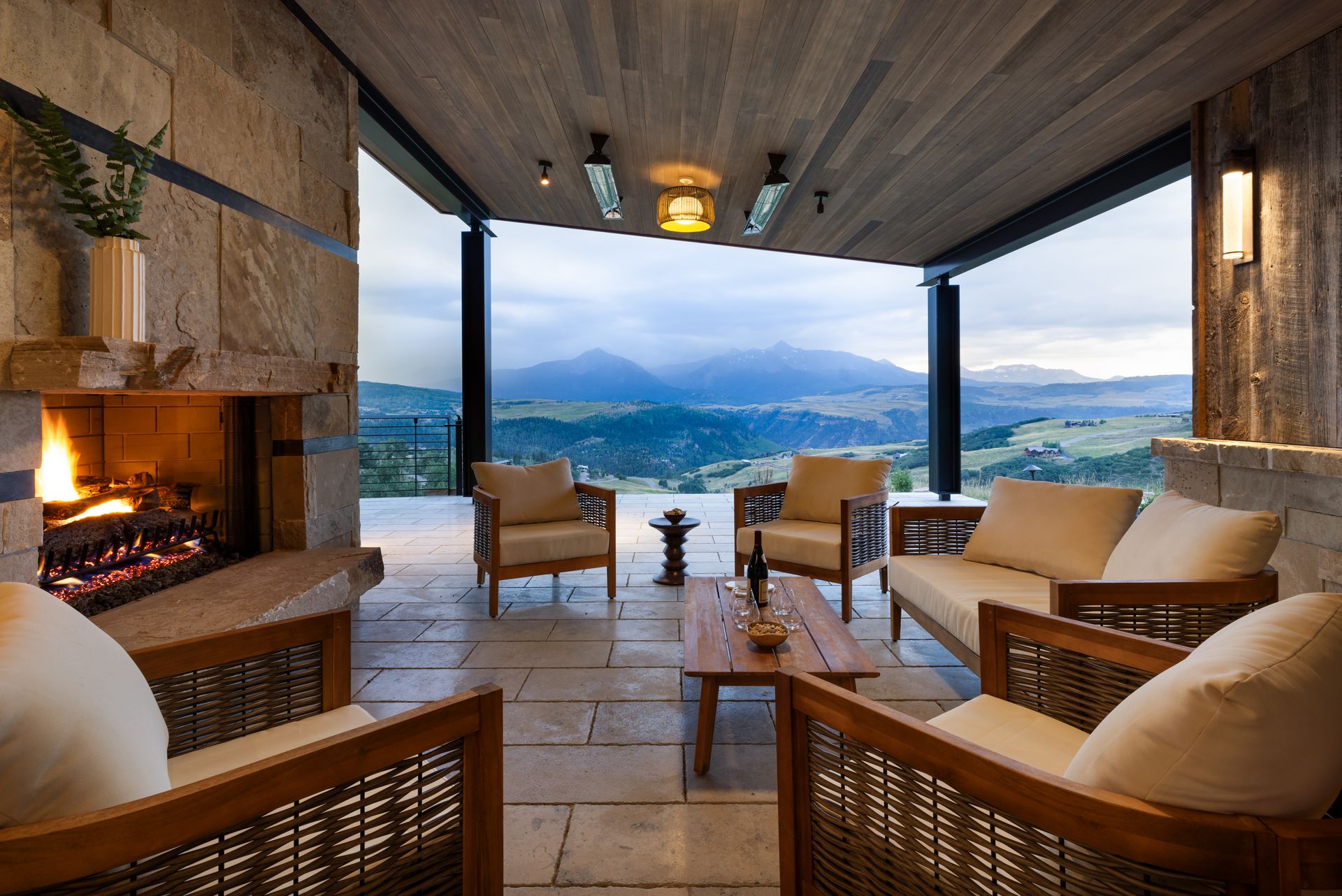 A living room with a fireplace and mountains in the background