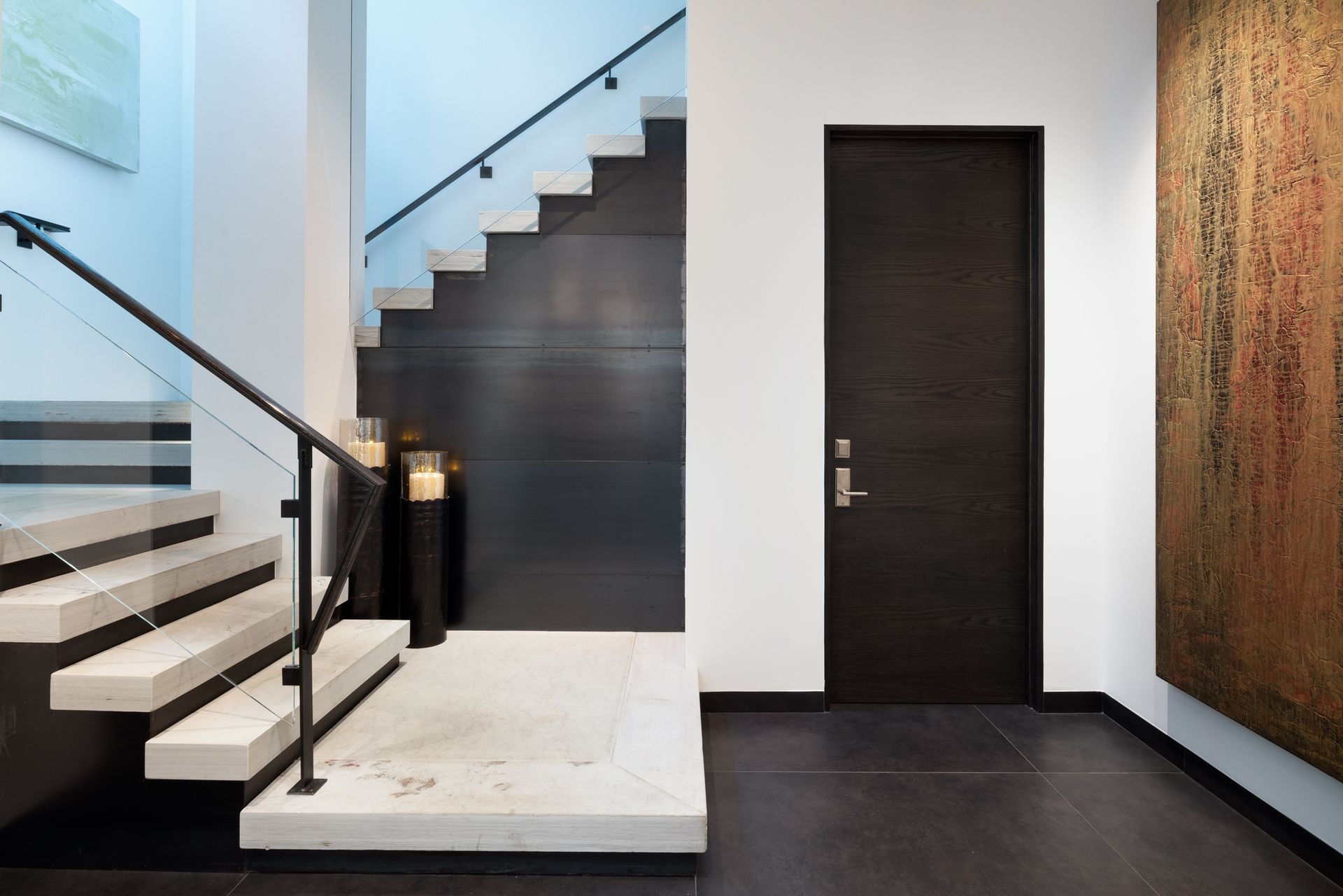 A hallway with a staircase and a door