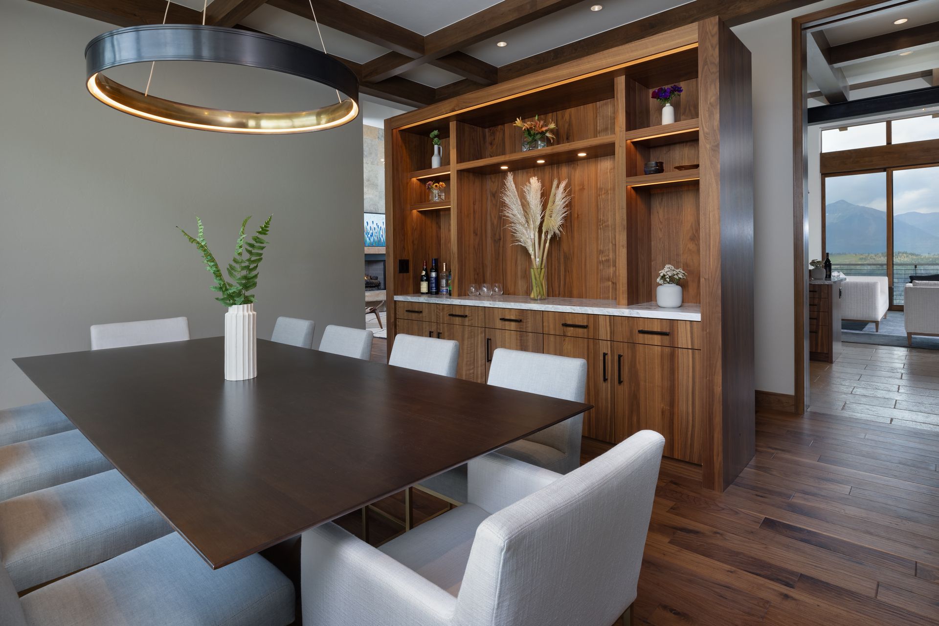 A dining room with a long table and white chairs