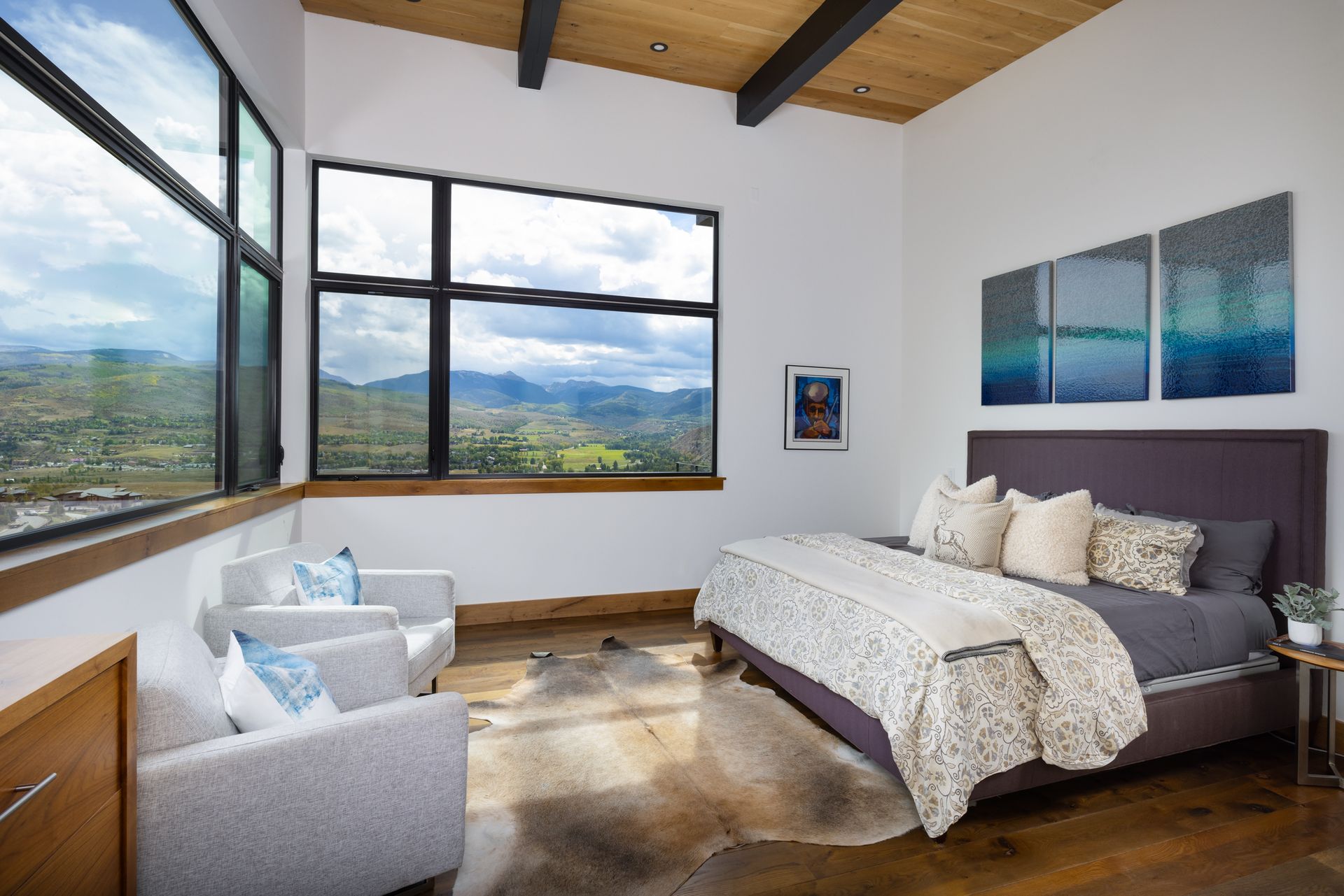 There is a large bed in the middle of the room with a view of the mountains.