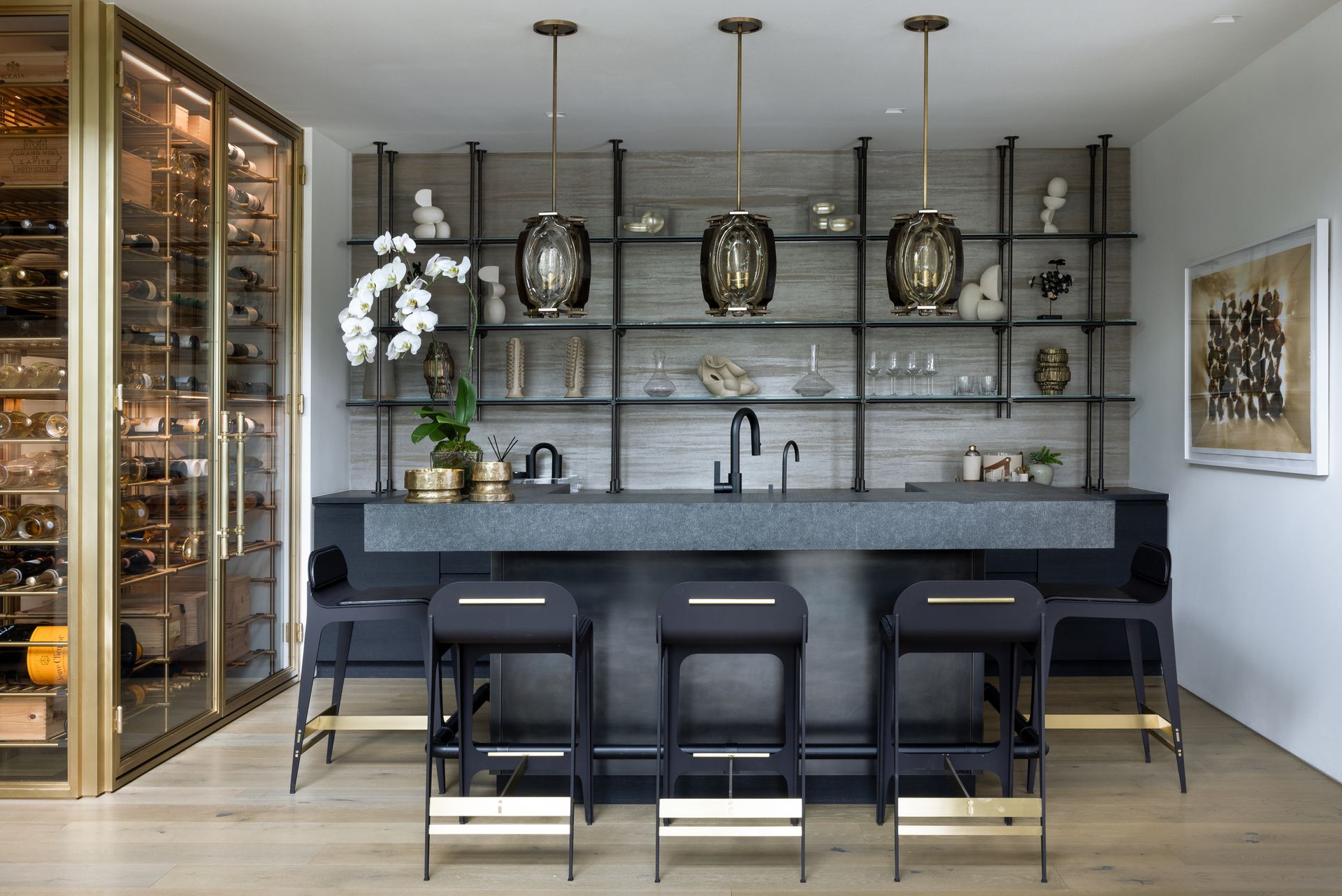 A kitchen with a bar and stools and a wine cellar
