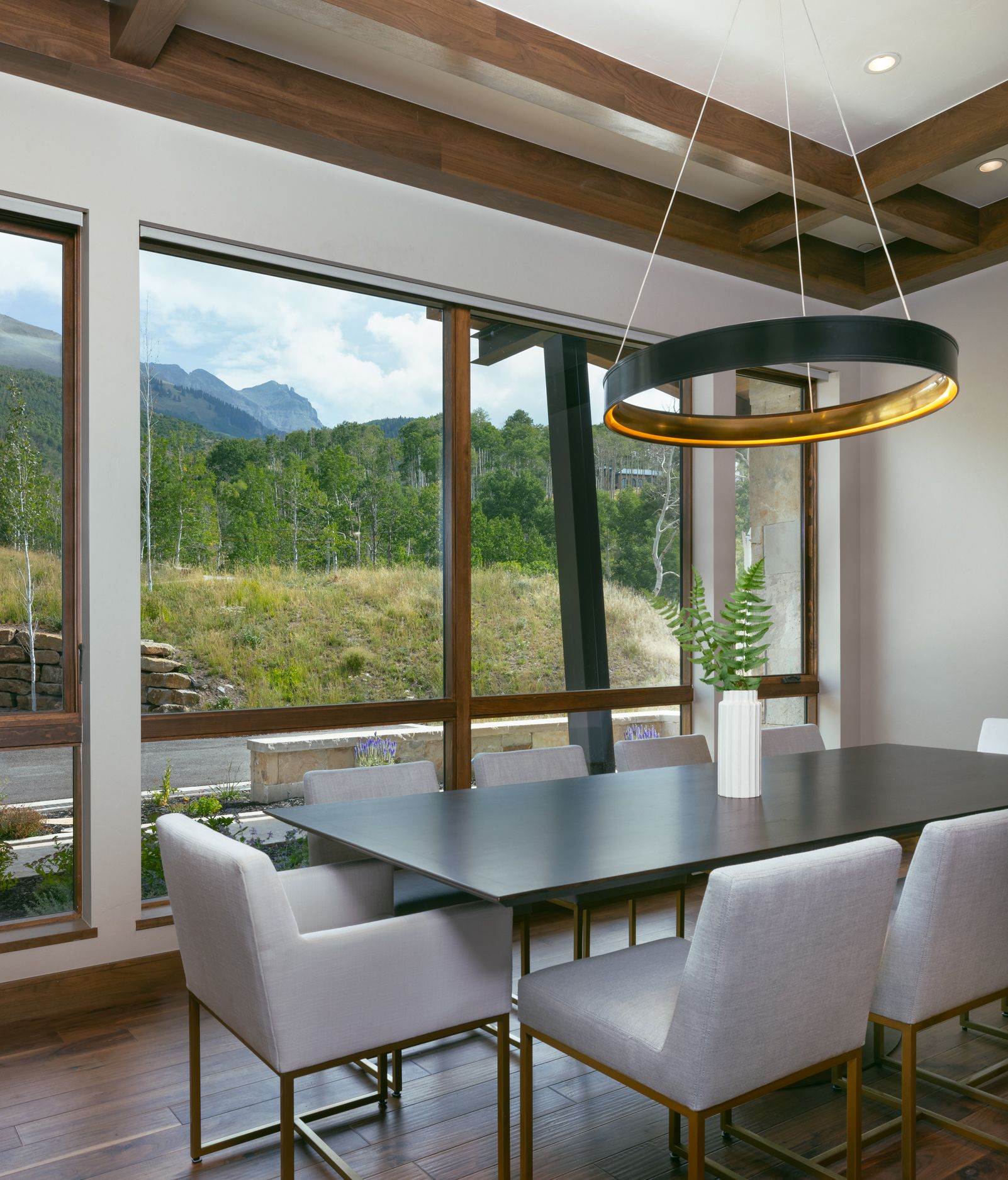 A dining room with a table and chairs and a large window