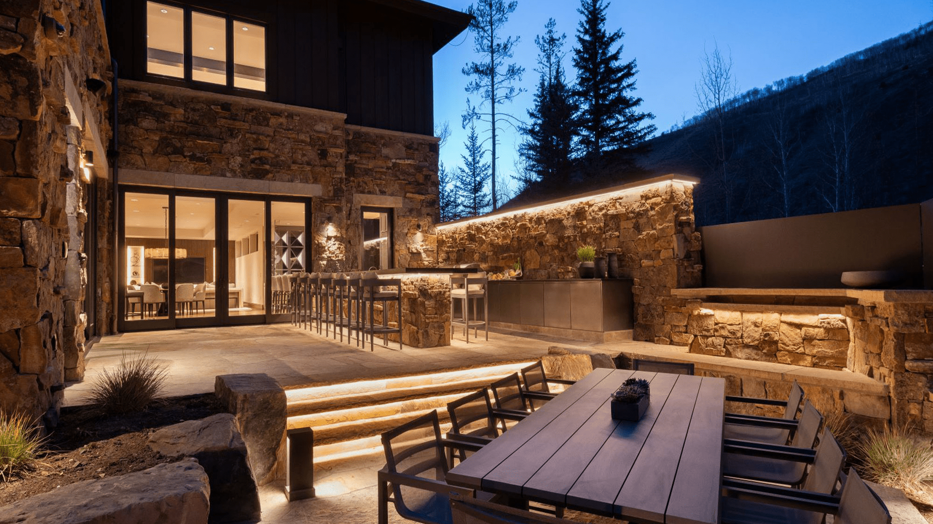 There is a table and chairs in the backyard of a house.
