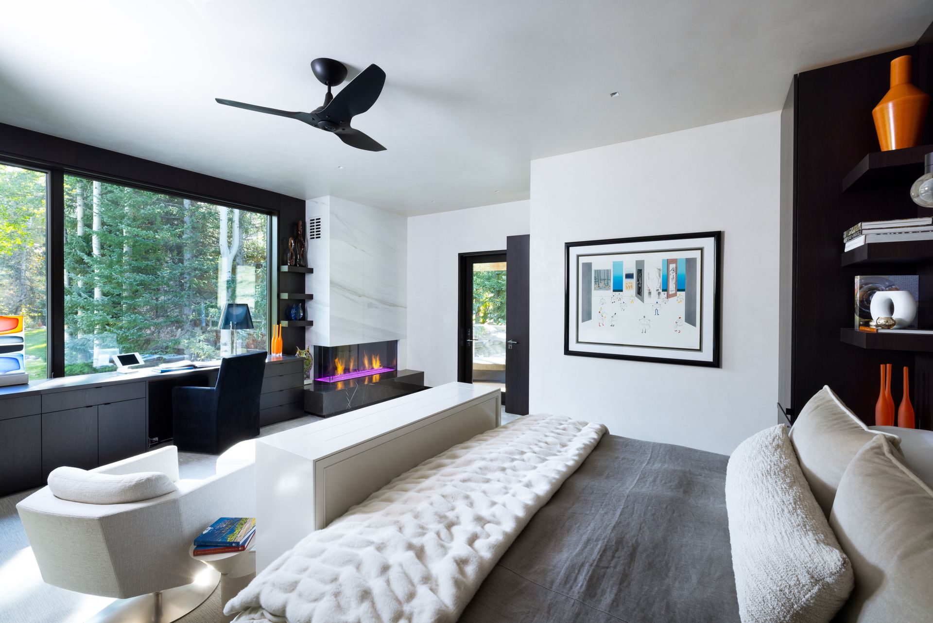 A bedroom with a fireplace and a ceiling fan