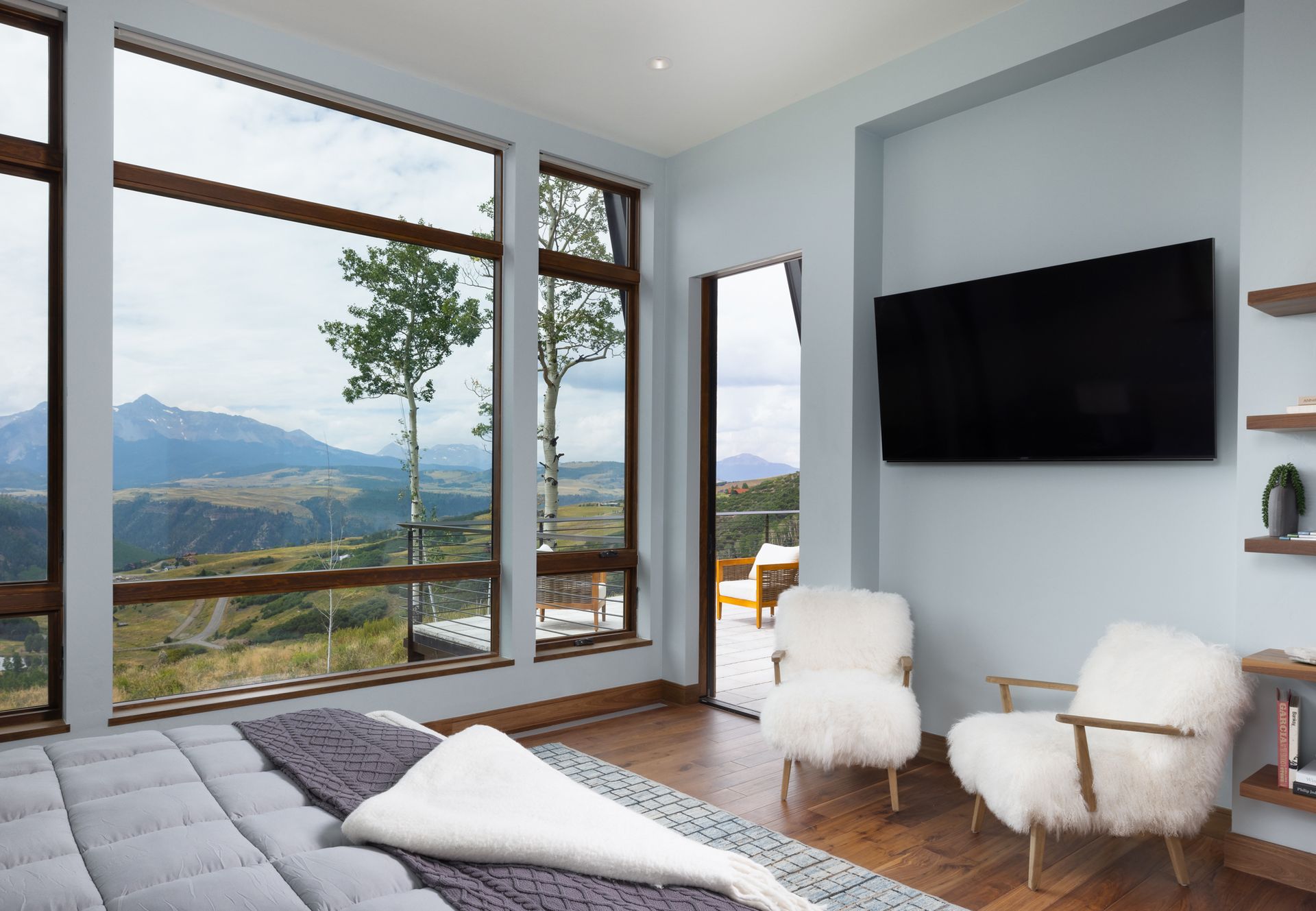 A bedroom with a bed , chairs and a flat screen tv