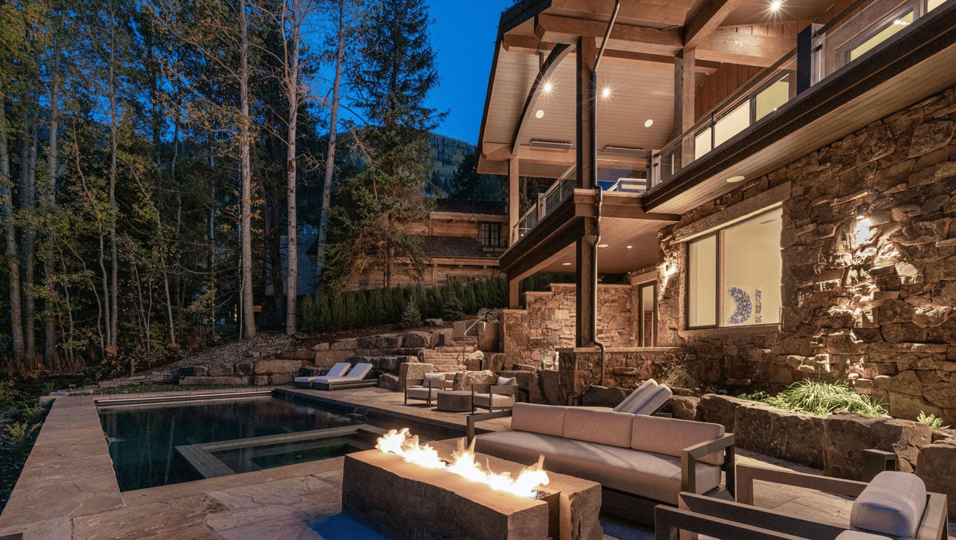 A large house with a fire pit in front of it.