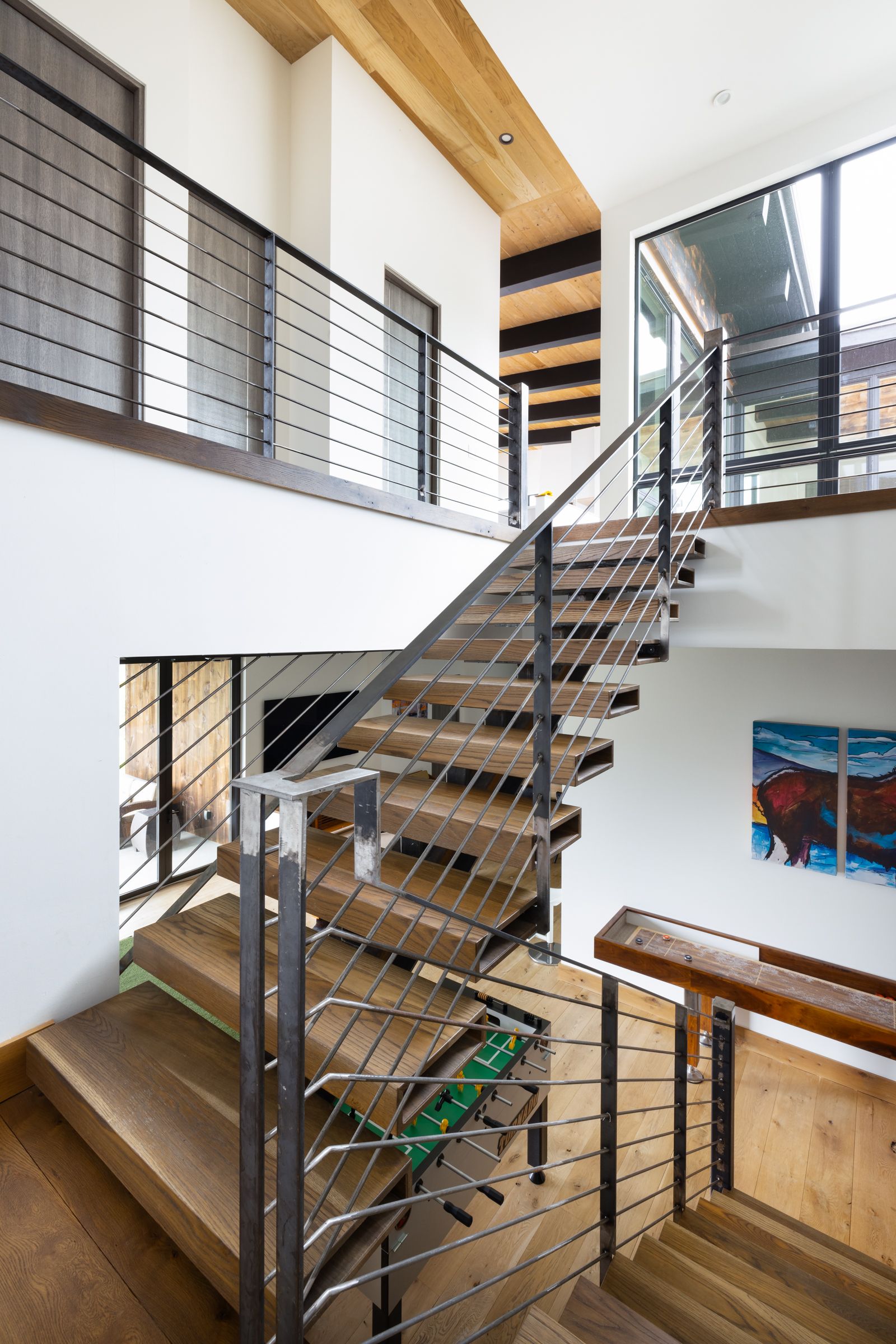 A wooden staircase with a metal railing in a house.