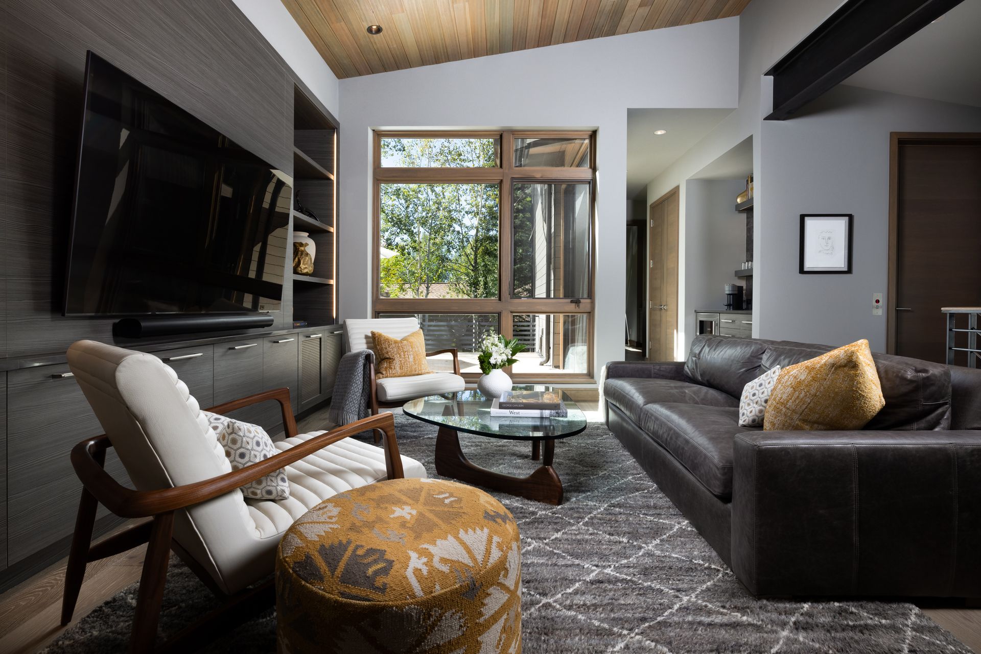 A living room with a couch , chair , coffee table and television.