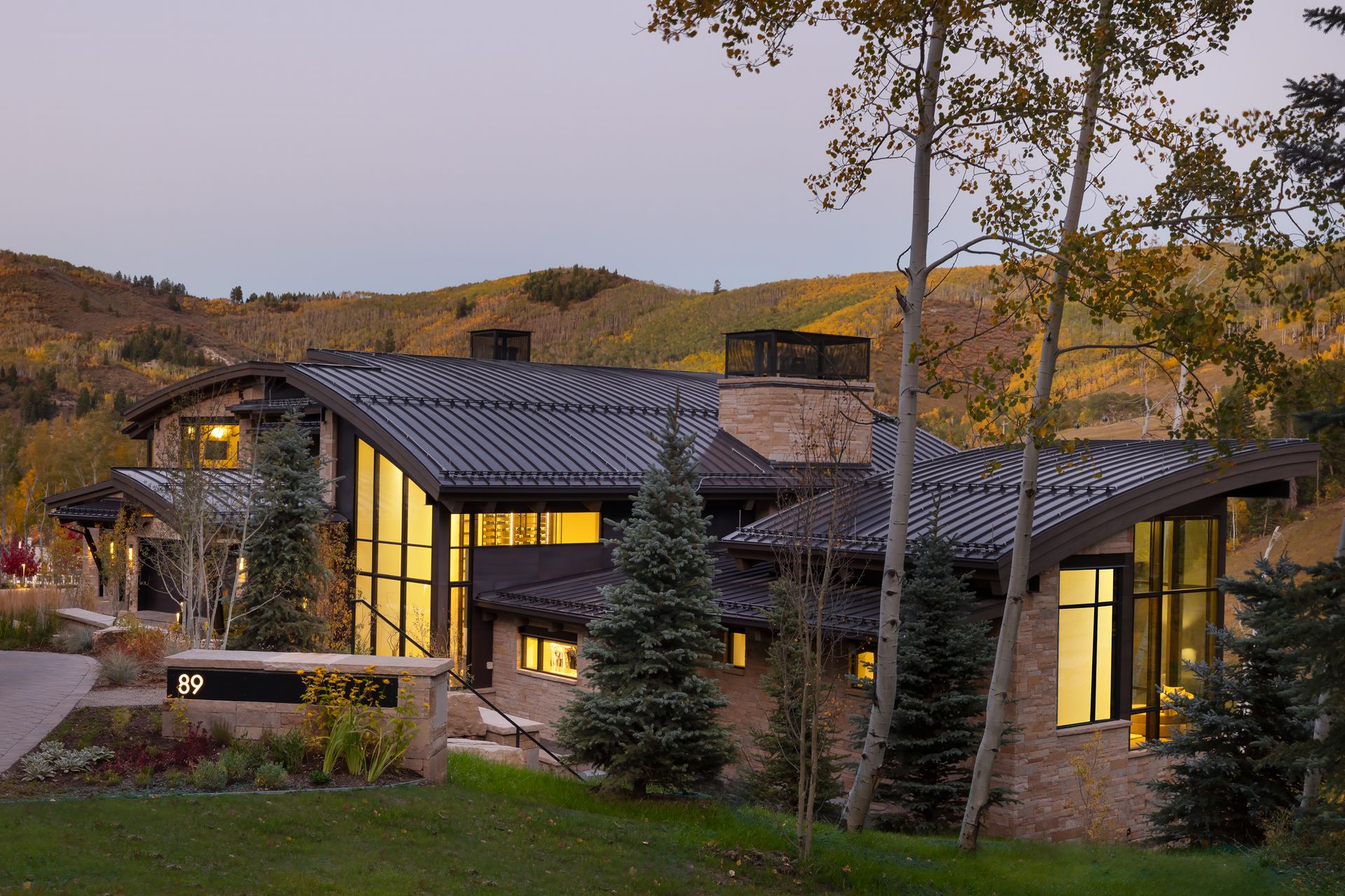 A large house sits in the middle of a lush green field