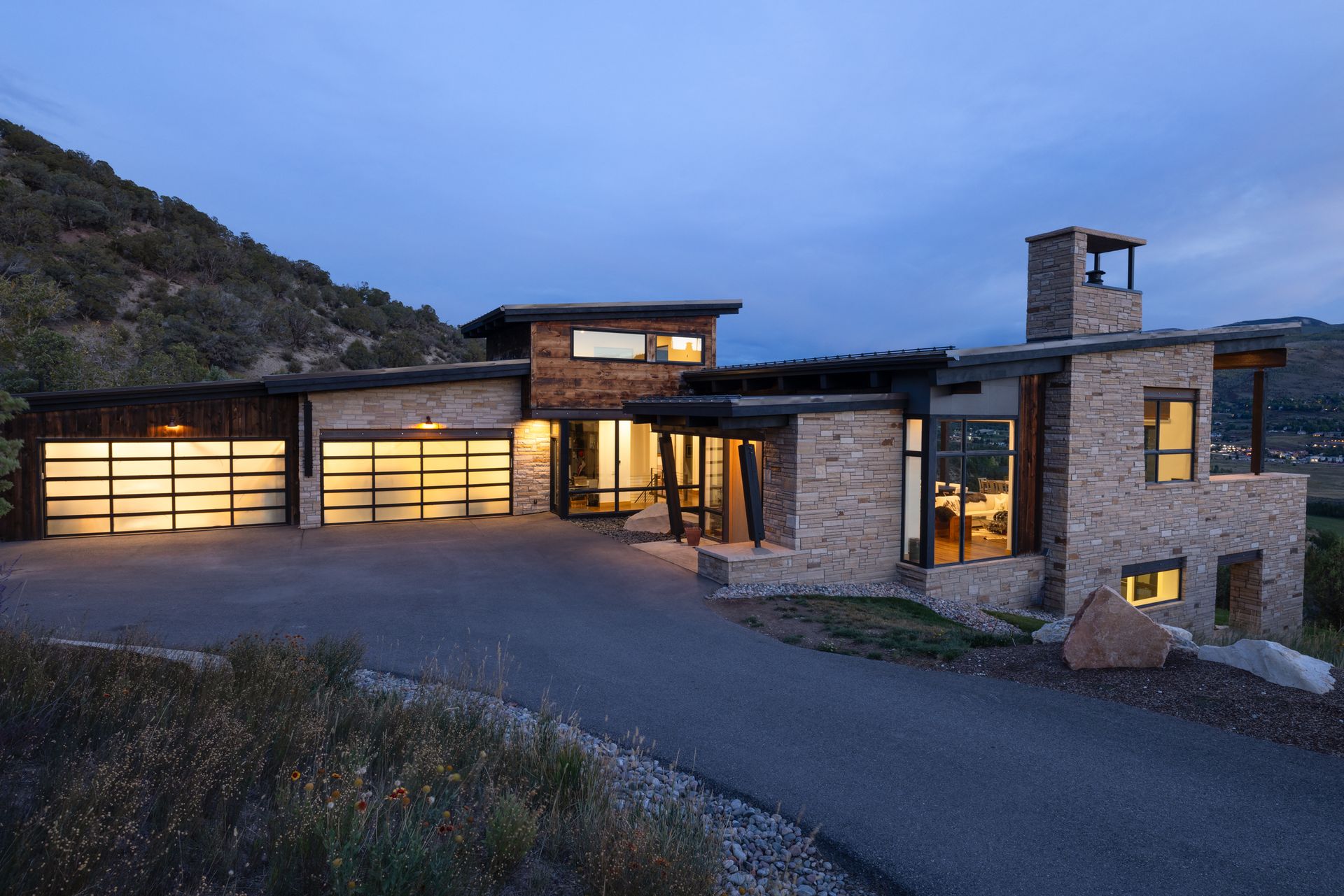 A large house with a lot of windows is sitting on top of a hill.