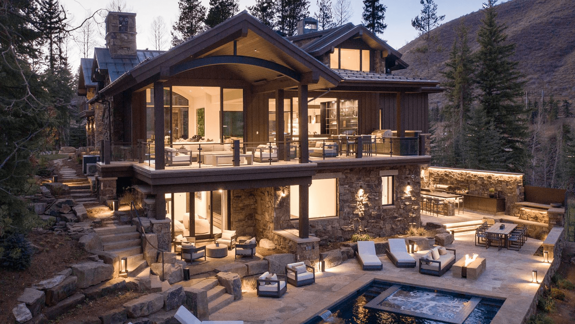 A large house with a pool in the backyard is surrounded by trees.
